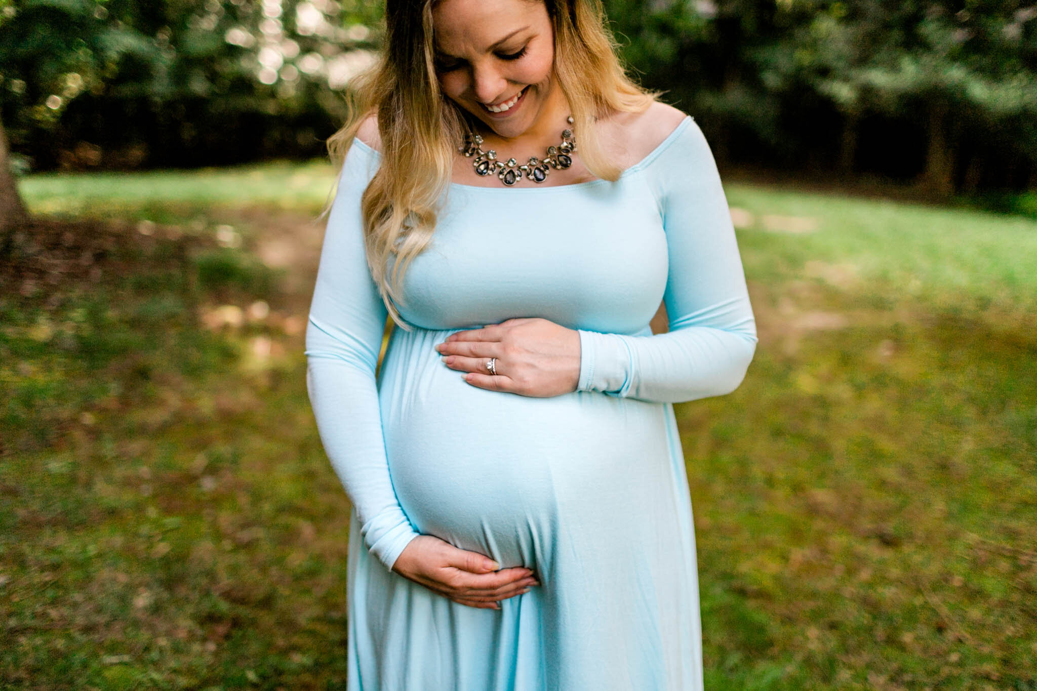 Raleigh Maternity Photographer | By G. Lin Photography | Woman looking down and touching baby bump