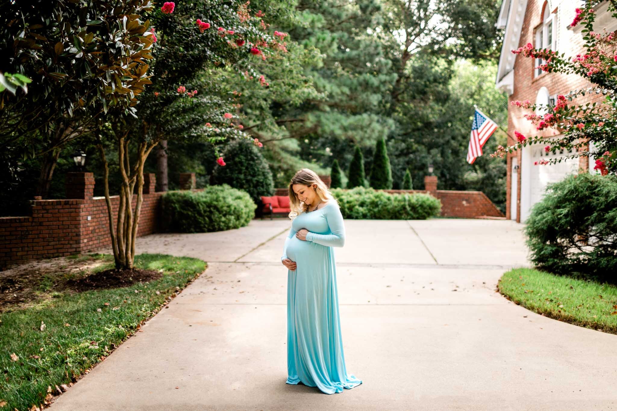 Raleigh Maternity Photographer | By G. Lin Photography | Woman standing outside and holding baby bump belly