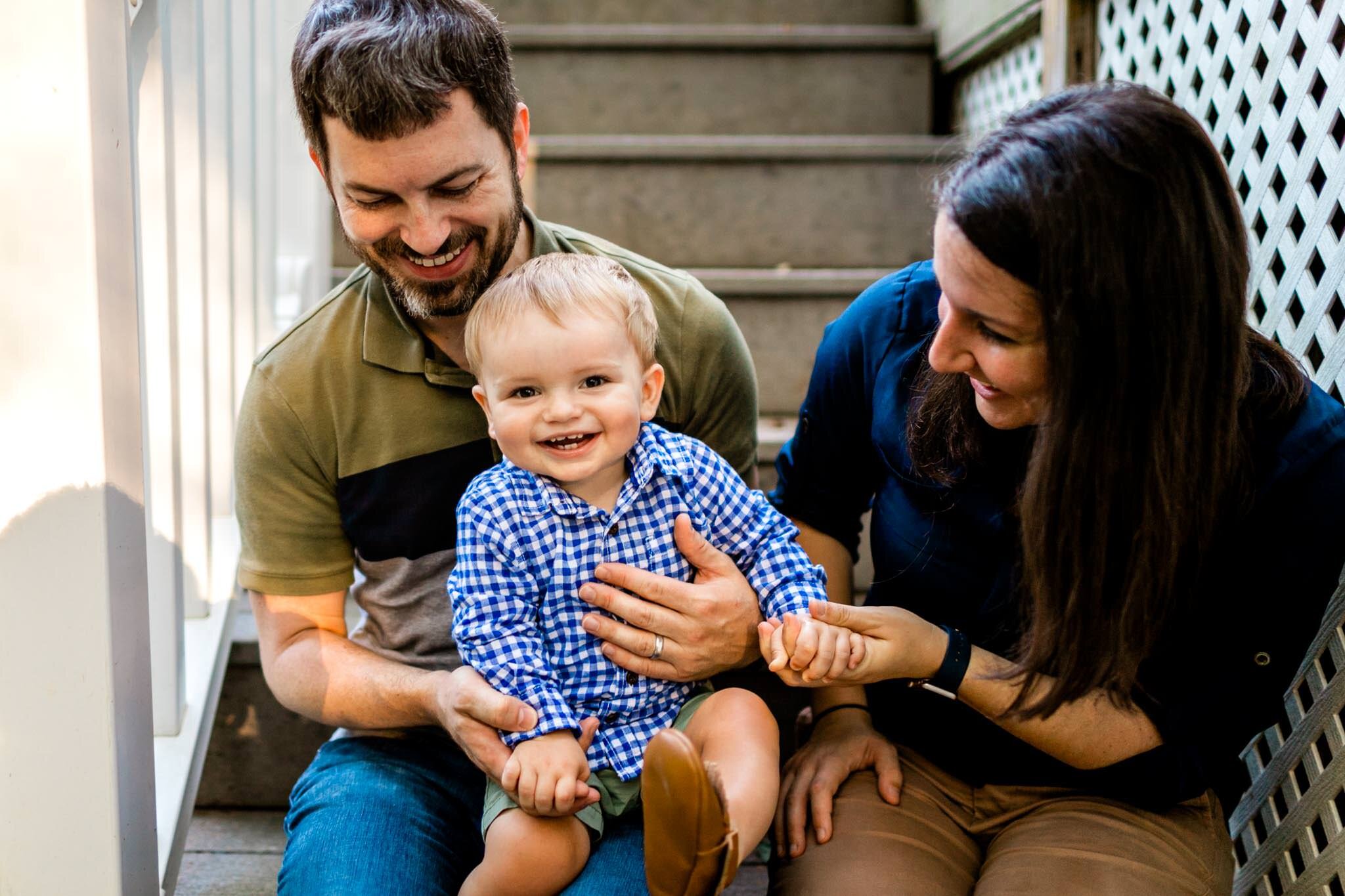 Raleigh Family Photographer | By G. Lin Photography | Baby boy smiling at camera and sitting on dad's lap