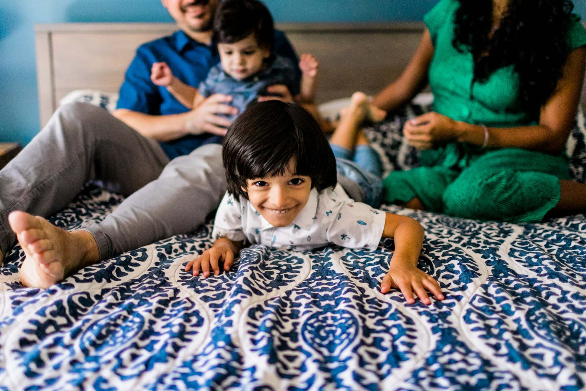 Durham Family Photographer | By G. Lin Photography | Lifestyle family session at home | Young boy crawling on bed smiling