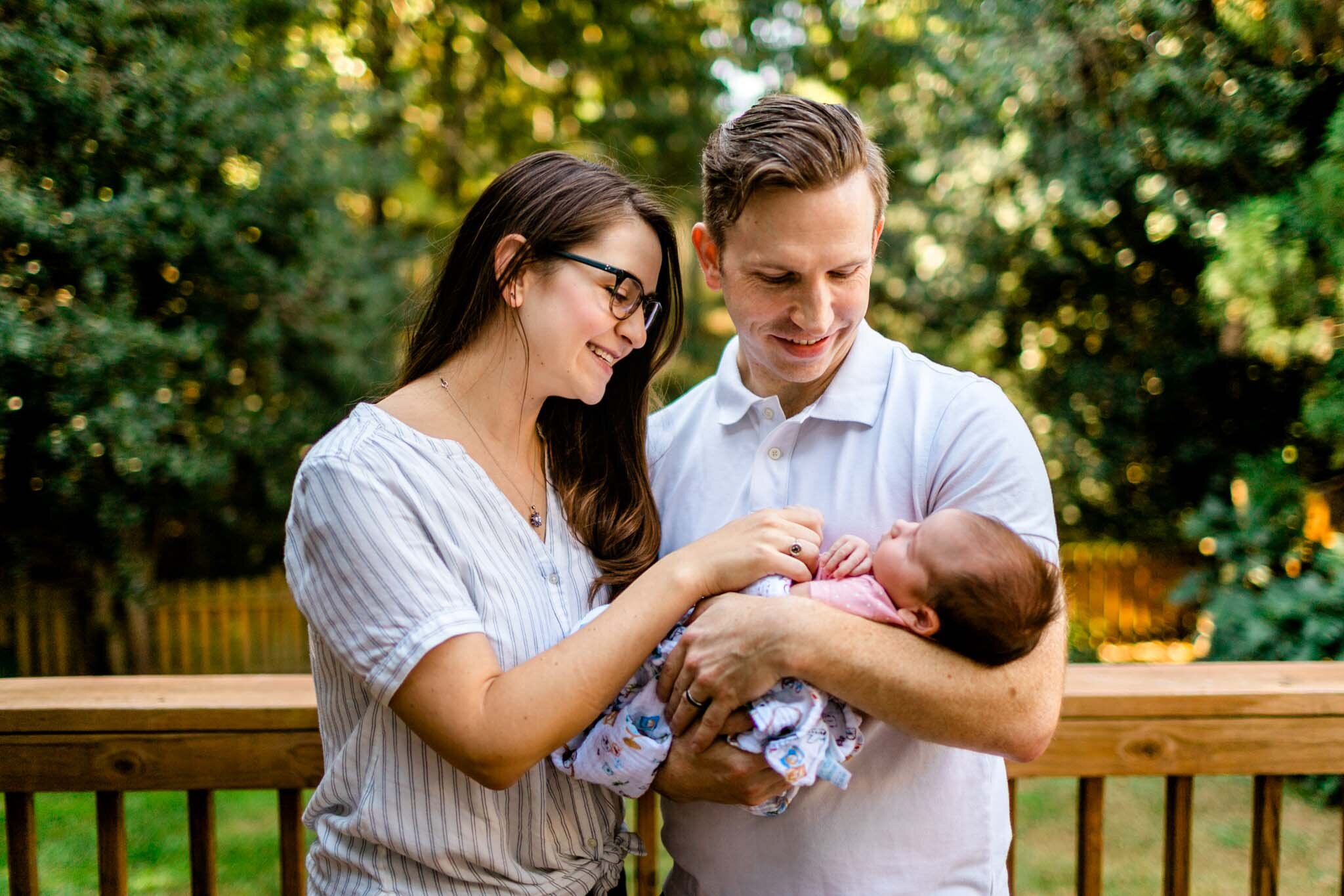 Raleigh Newborn Photographer | By G. Lin Photography | Outdoor photo of mother and father holding baby girl