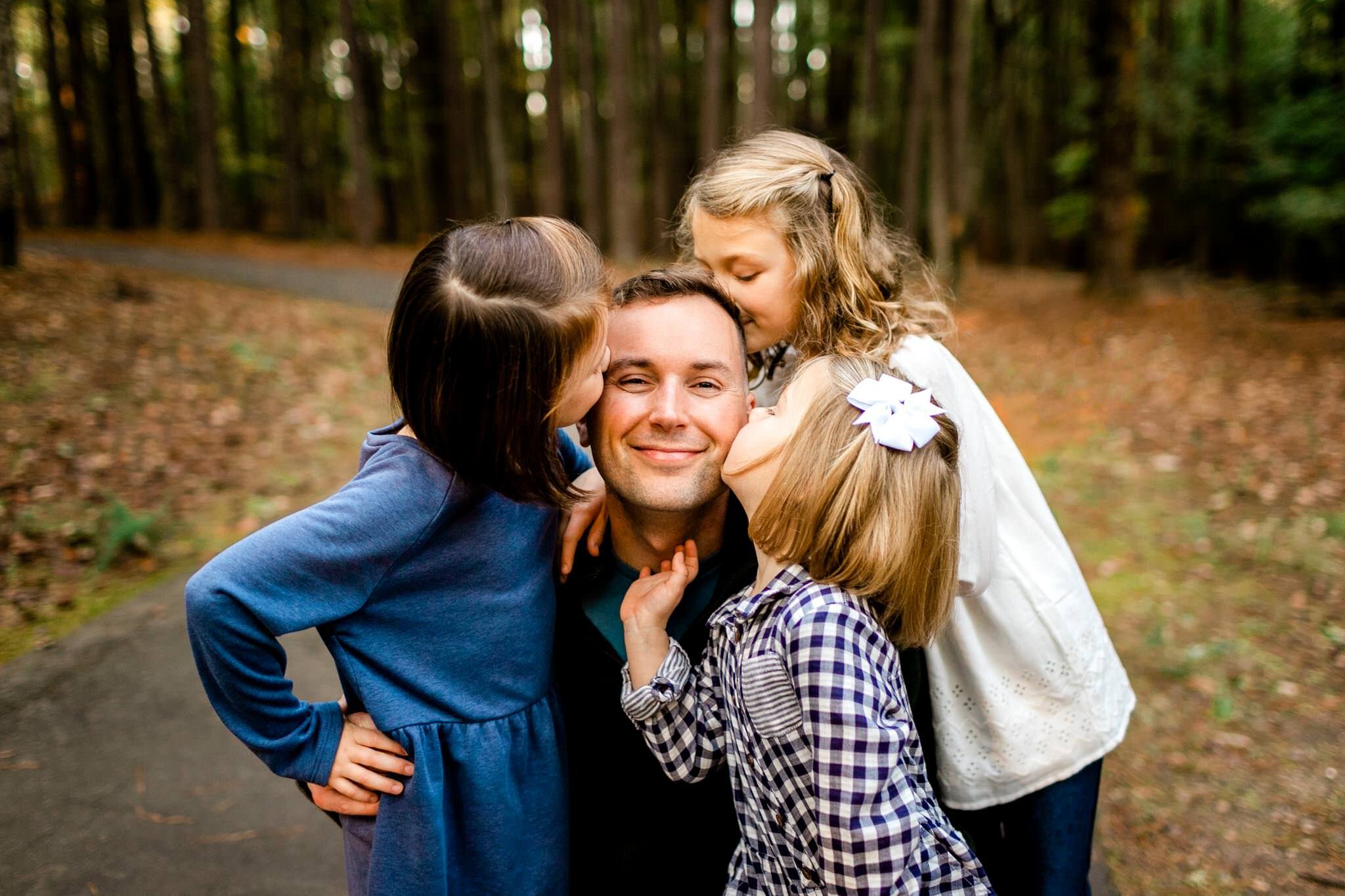 Raleigh Family Photographer | Umstead Park | By G. Lin Photography | Three girls giving dad a kiss on the cheek