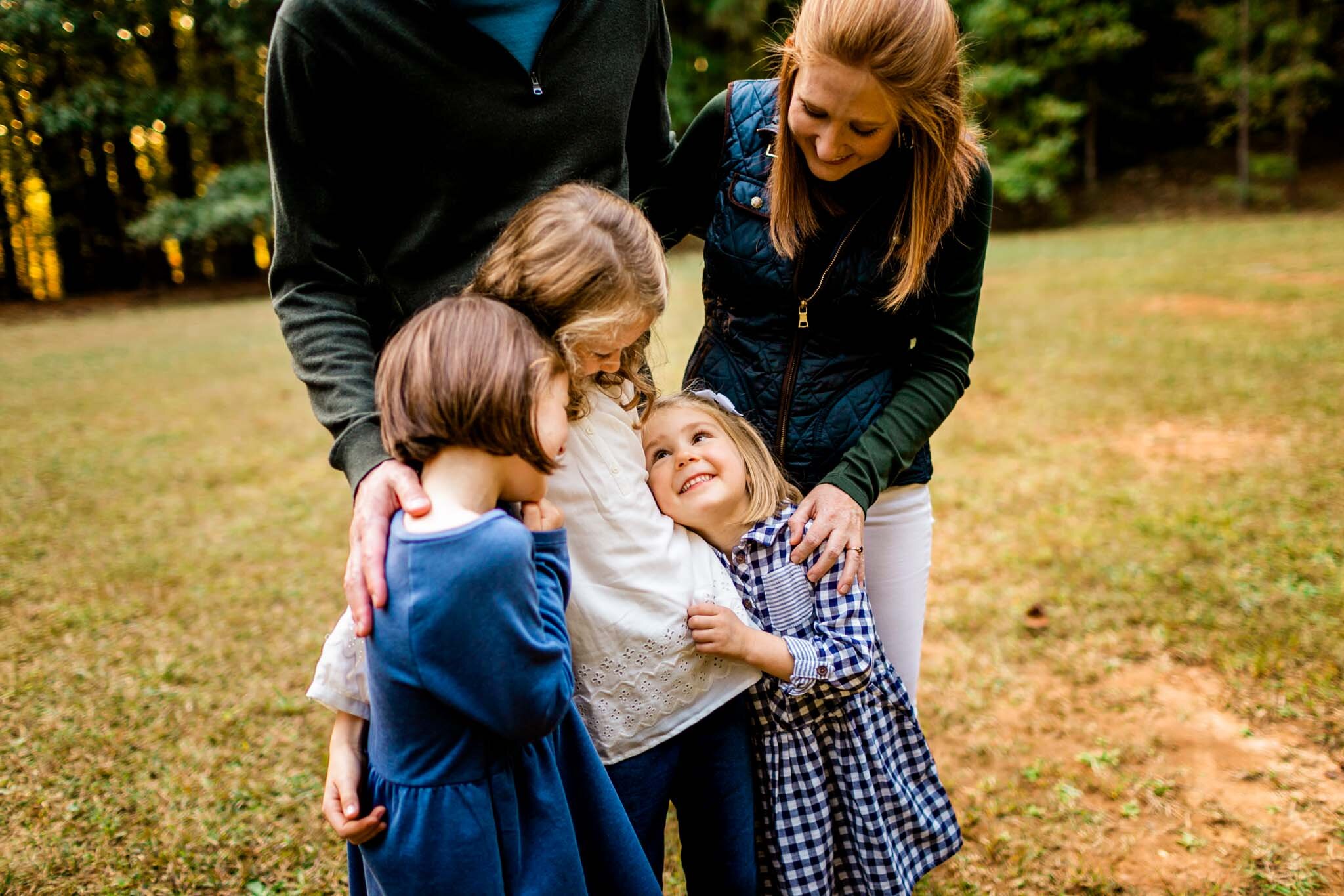 Raleigh Family Photographer | Umstead Park | By G. Lin Photography | Candid photo of family standing outside in field