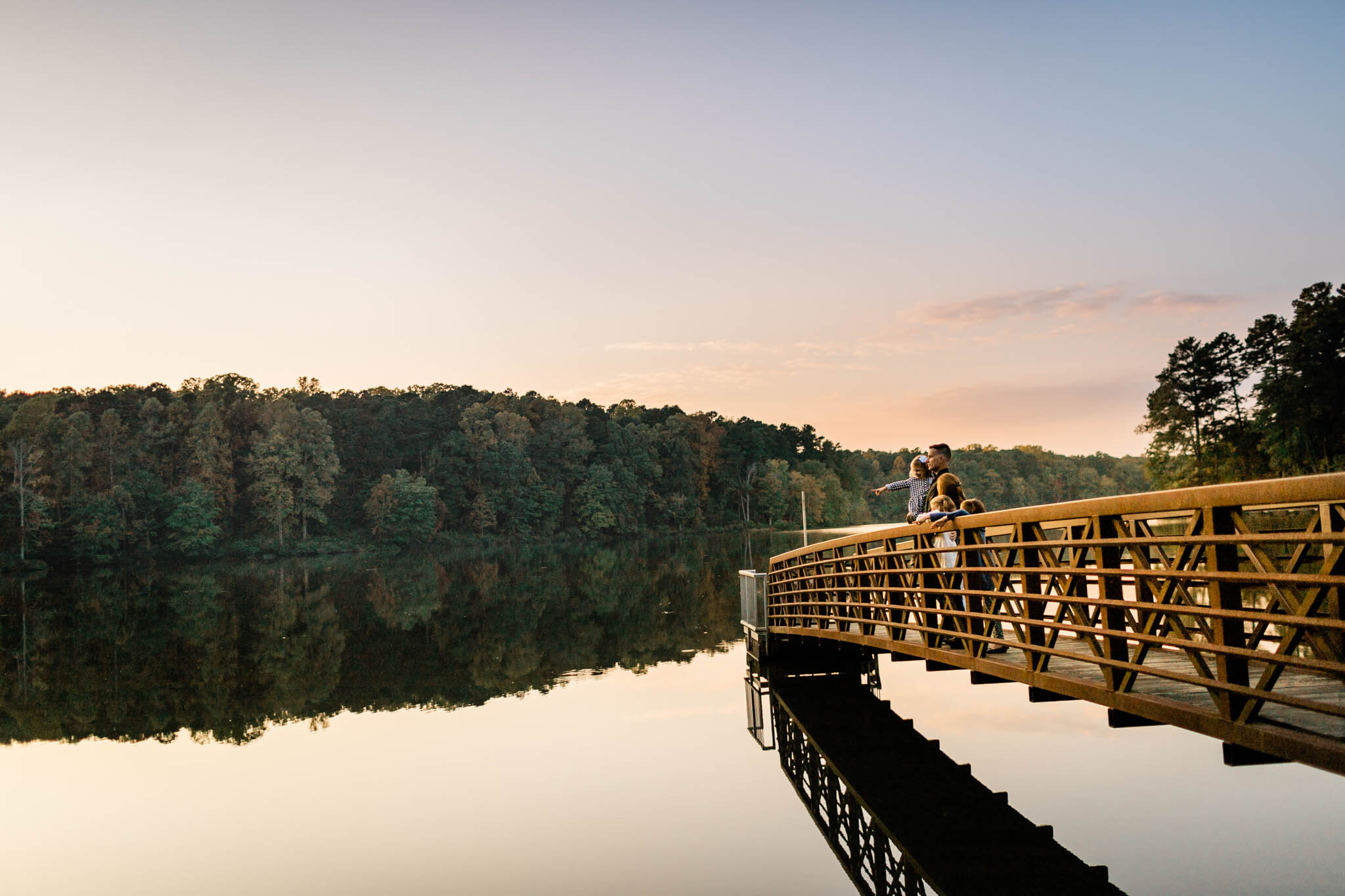 Raleigh Family Photographer | Umstead Park | By G. Lin Photography | Family looking at lake and standing on bridge