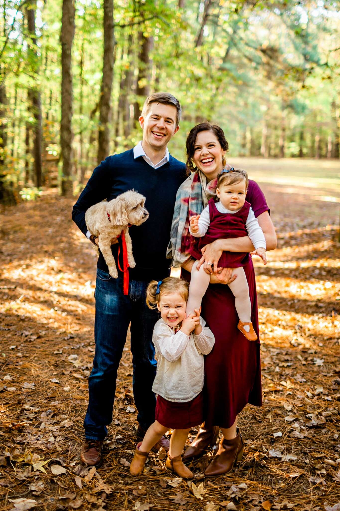 Raleigh Family Photographer | By G. Lin Photography | Umstead Park | Fall family portrait | Family holding dog and children and smiling