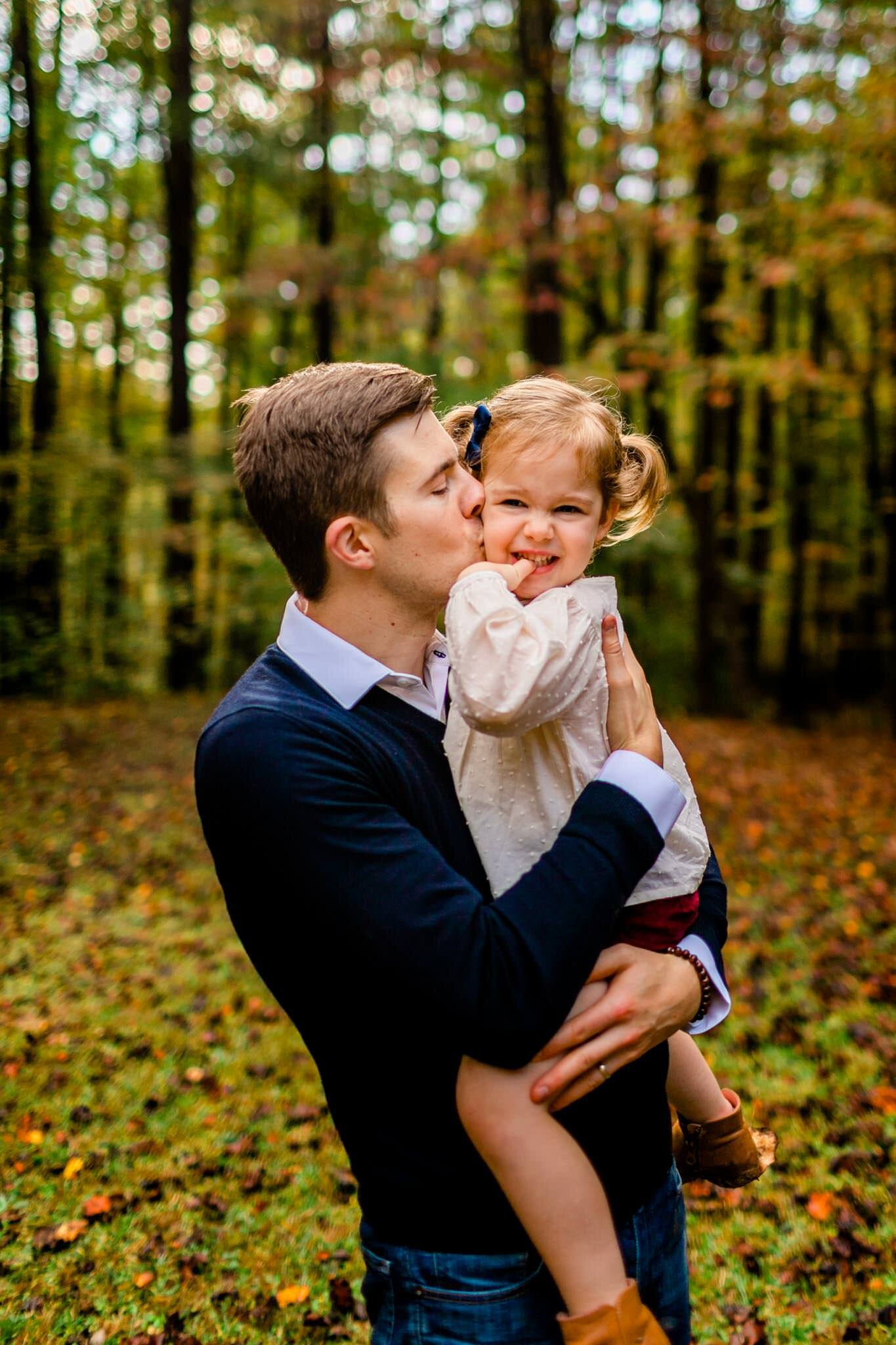 Raleigh Family Photographer | By G. Lin Photography | Umstead Park | Dad giving kiss to young daughter
