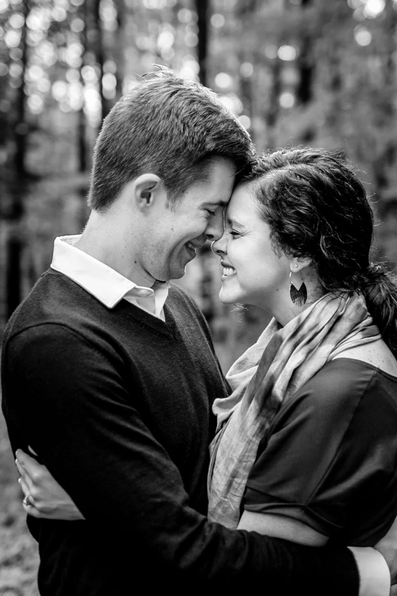 Raleigh Family Photographer | By G. Lin Photography | Umstead Park | Black and white image of husband and wife hugging one another and smiling