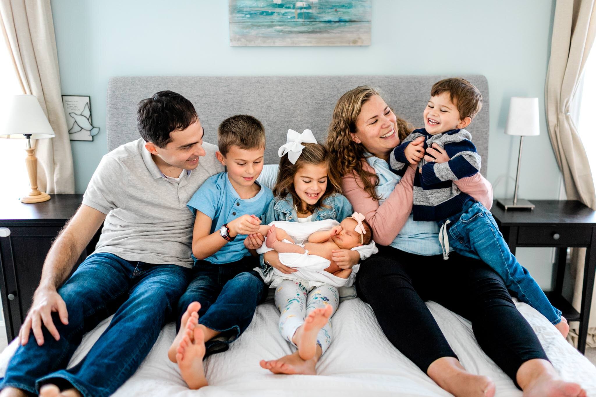 Raleigh Newborn Photographer | By G. Lin Photography | Family laughing together on the bed