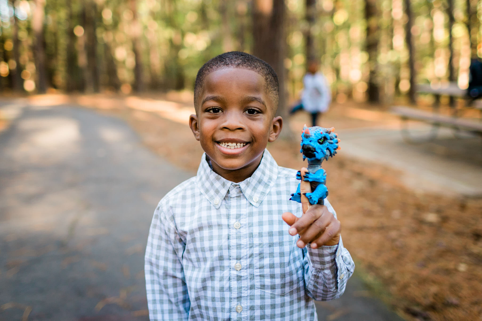 Raleigh Family Photographer | By G. Lin Photography | Umstead Park | Young boy holding up figurine