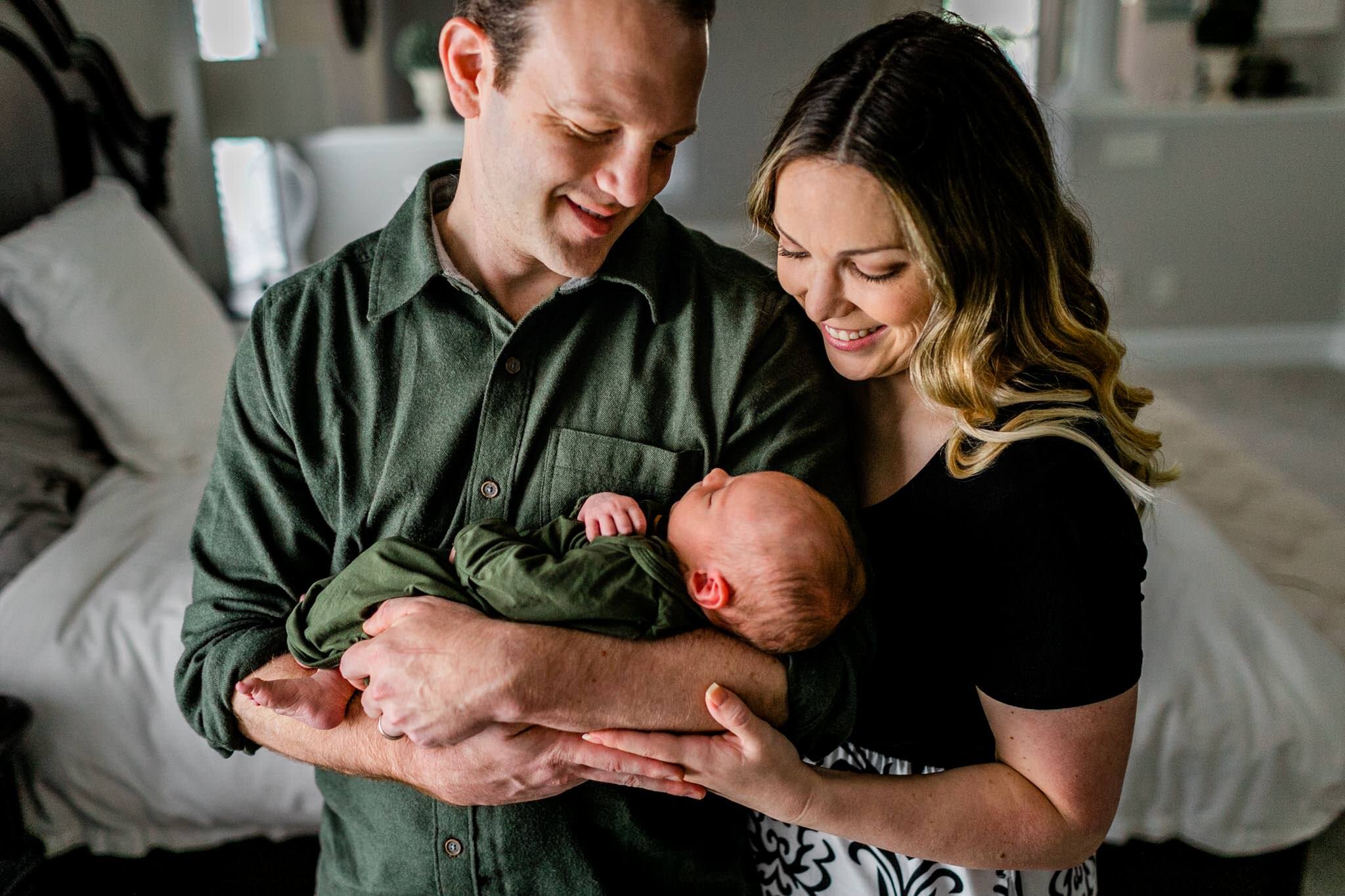 Raleigh Newborn Photographer | By G. Lin Photography | Beautiful lifestyle newborn family photo standing by window and holding baby