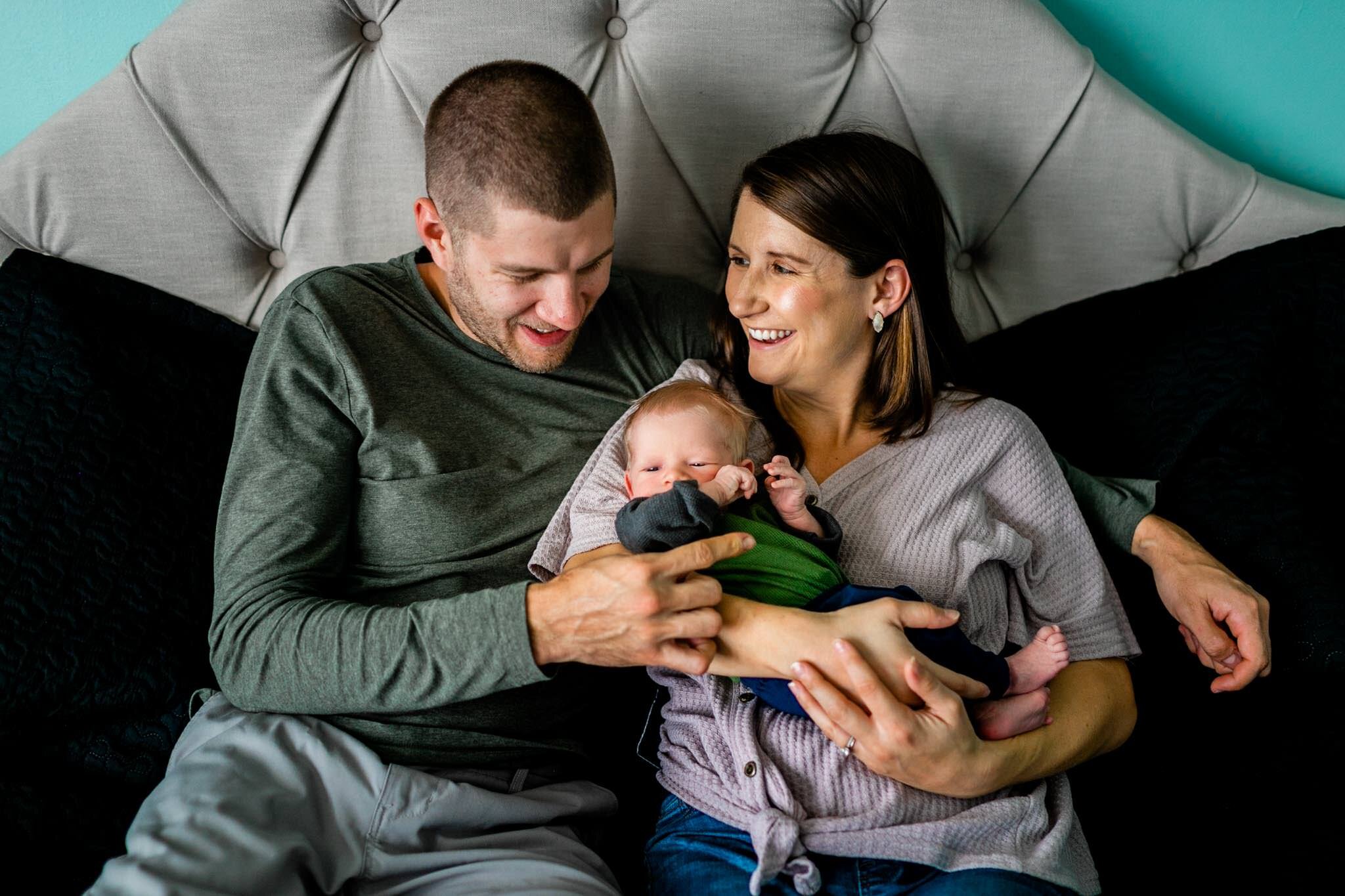 Durham Newborn Photographer | By G. Lin Photography | Mom and dad sitting on bed with baby boy