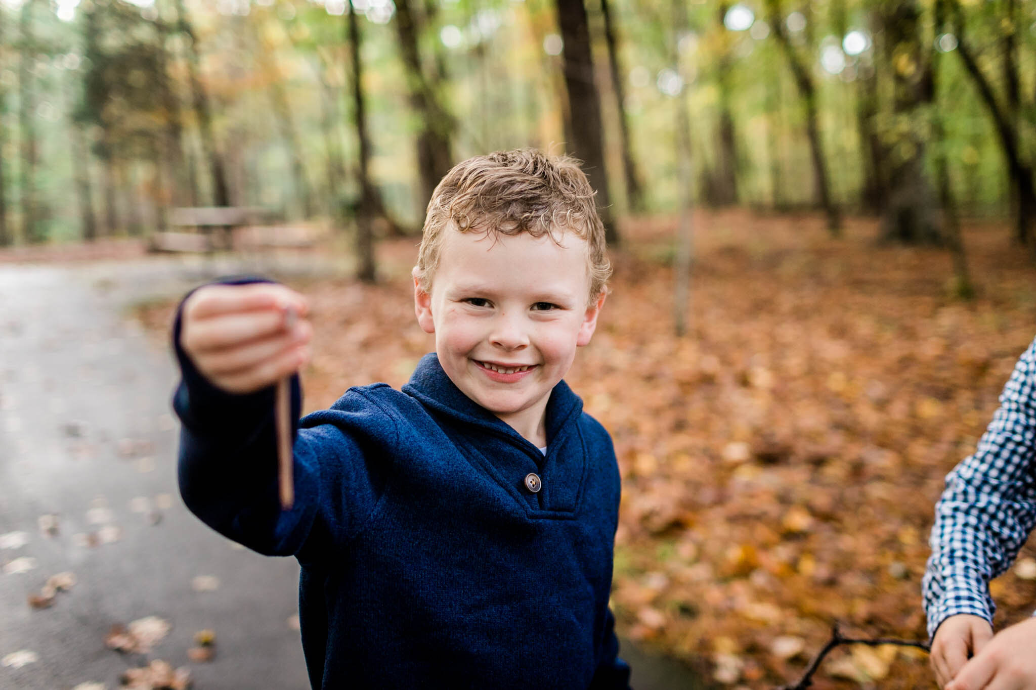 Raleigh Family Photographer | By G. Lin Photography | Umstead Park | Young boy holding earthworm and smiling