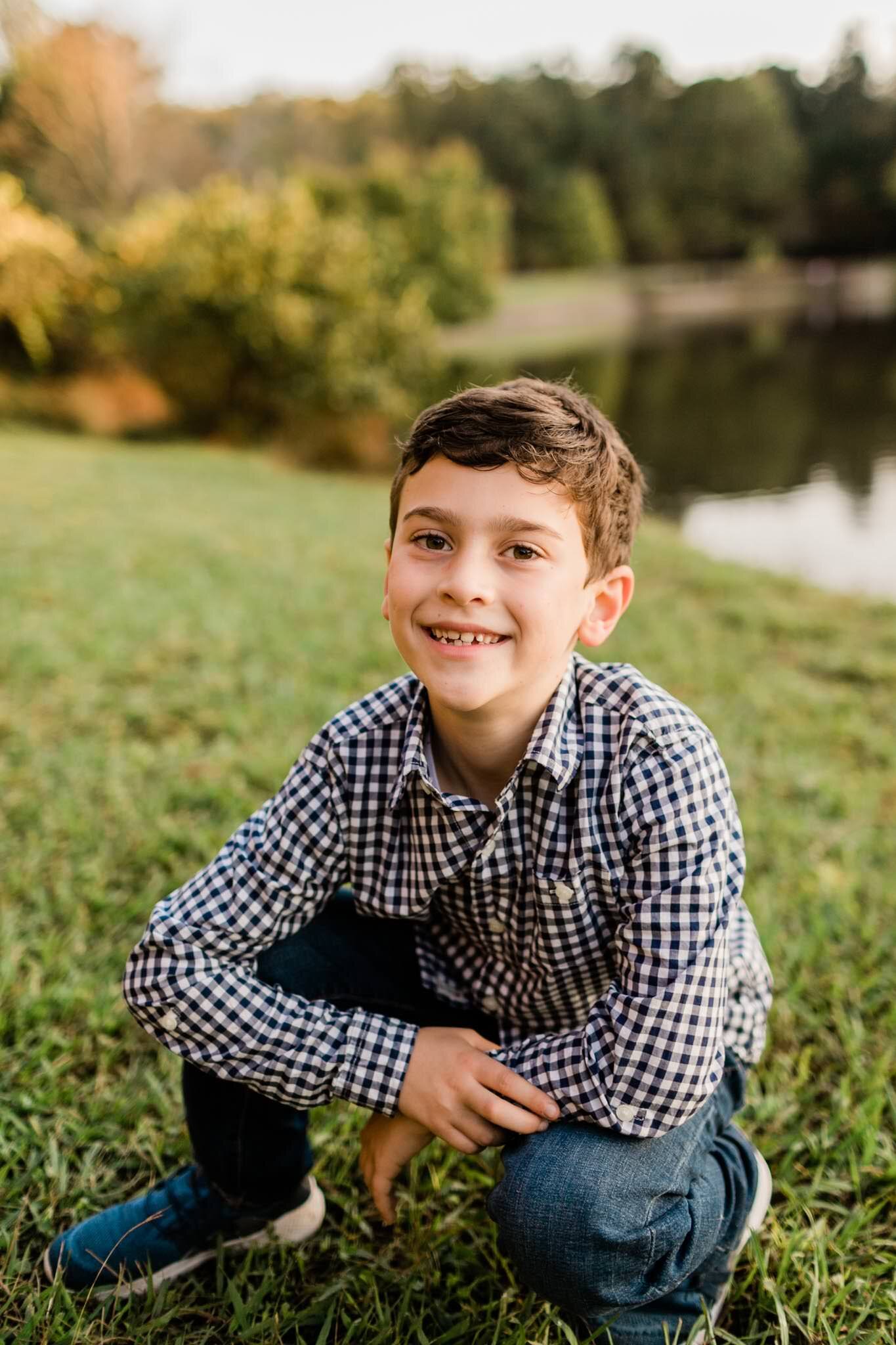 Raleigh Family Photographer | By G. Lin Photography | Umstead Park | Young boy smiling and sitting outside