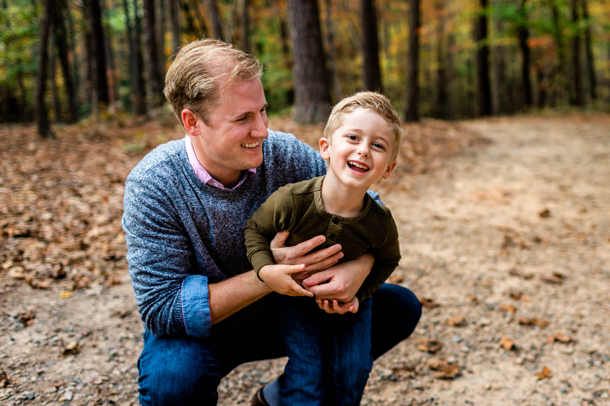 Raleigh Family Photographer at Umstead Park | By G. Lin Photography | Dad tickling and hugging son