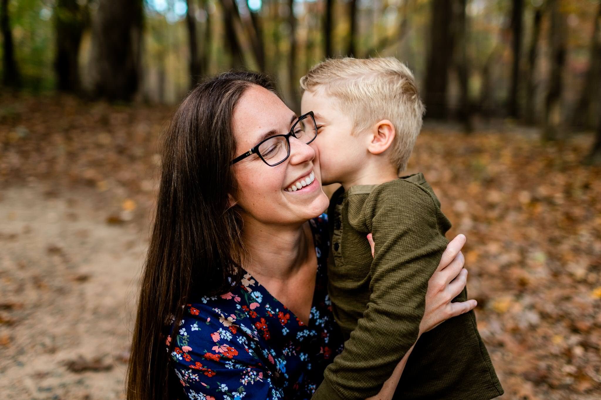Raleigh Family Photographer at Umstead Park | By G. Lin Photography | Young boy giving mother a kiss