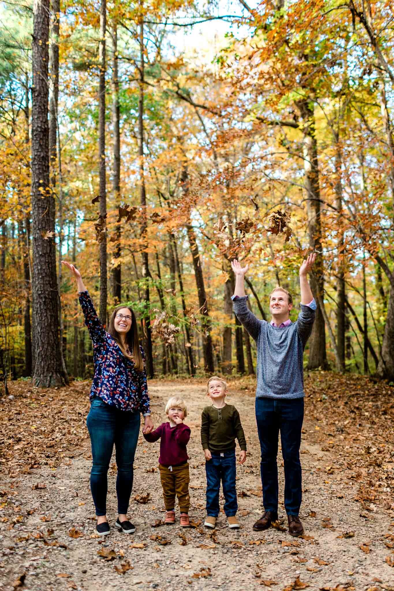 Raleigh Family Photographer at Umstead Park | By G. Lin Photography | Family tossing leaves in the air