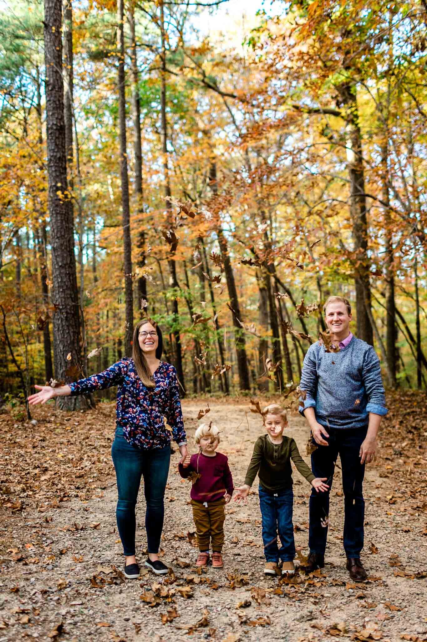 Raleigh Family Photographer at Umstead Park | By G. Lin Photography | Family tossing leaves in the air