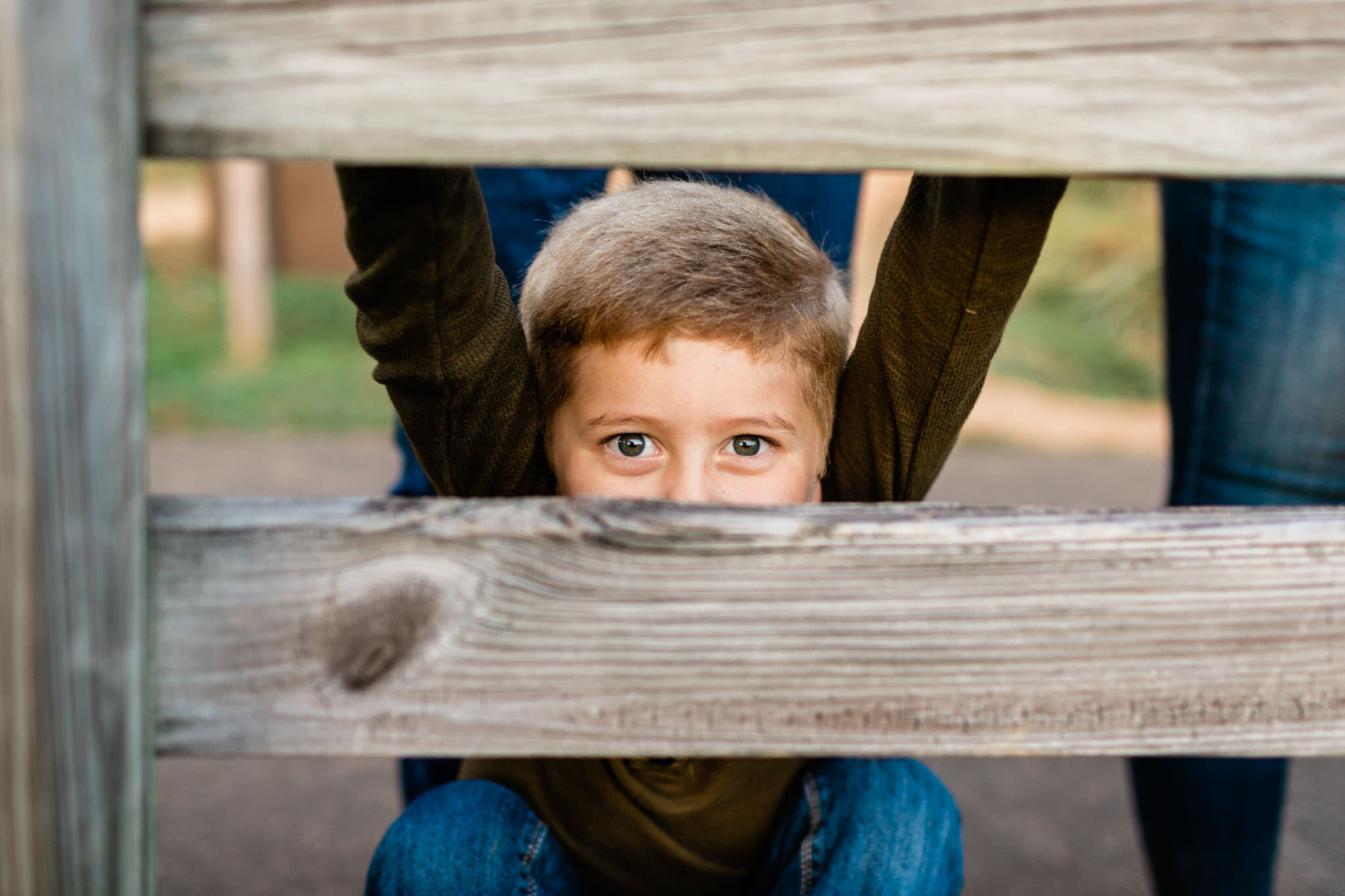 Raleigh Family Photographer at Umstead Park | By G. Lin Photography | Young boy looking through fence