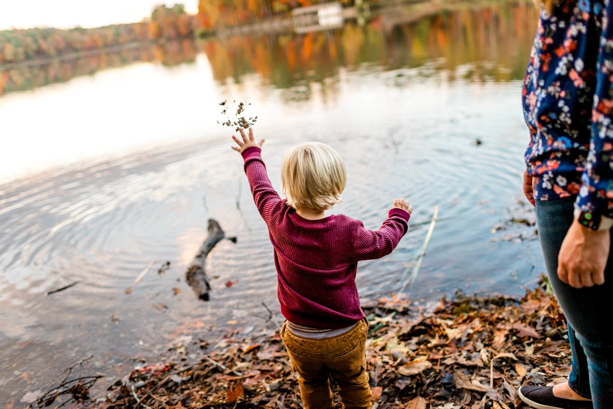 Raleigh Family Photographer at Umstead Park | By G. Lin Photography | Young boy in red shirt throwing rocks in lake