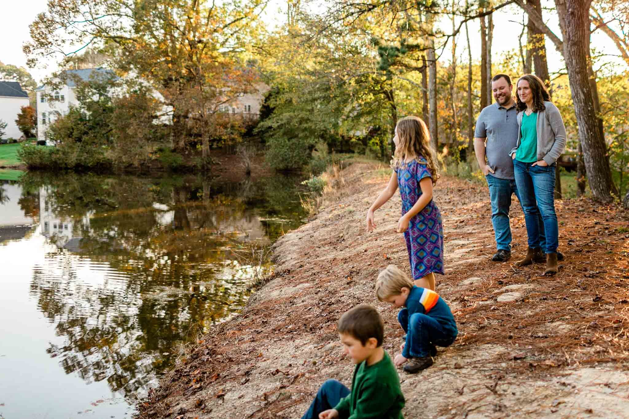 Apex Family Photographer | By G. Lin Photography | Family standing by lake and throwing rocks