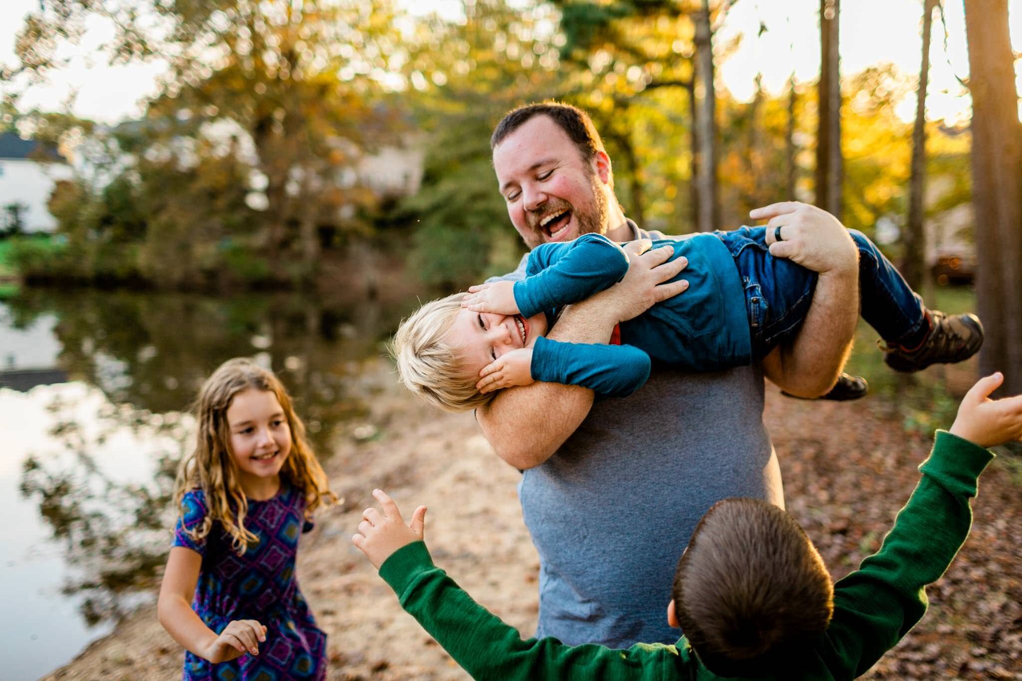 Apex Family Photographer | By G. Lin Photography | Dad picking up young boy and everyone laughing