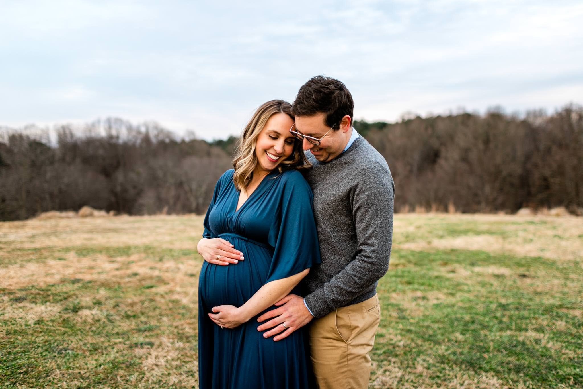 Raleigh Newborn Photographer | By G. Lin Photography | Couple standing in open field with woman holding baby bump