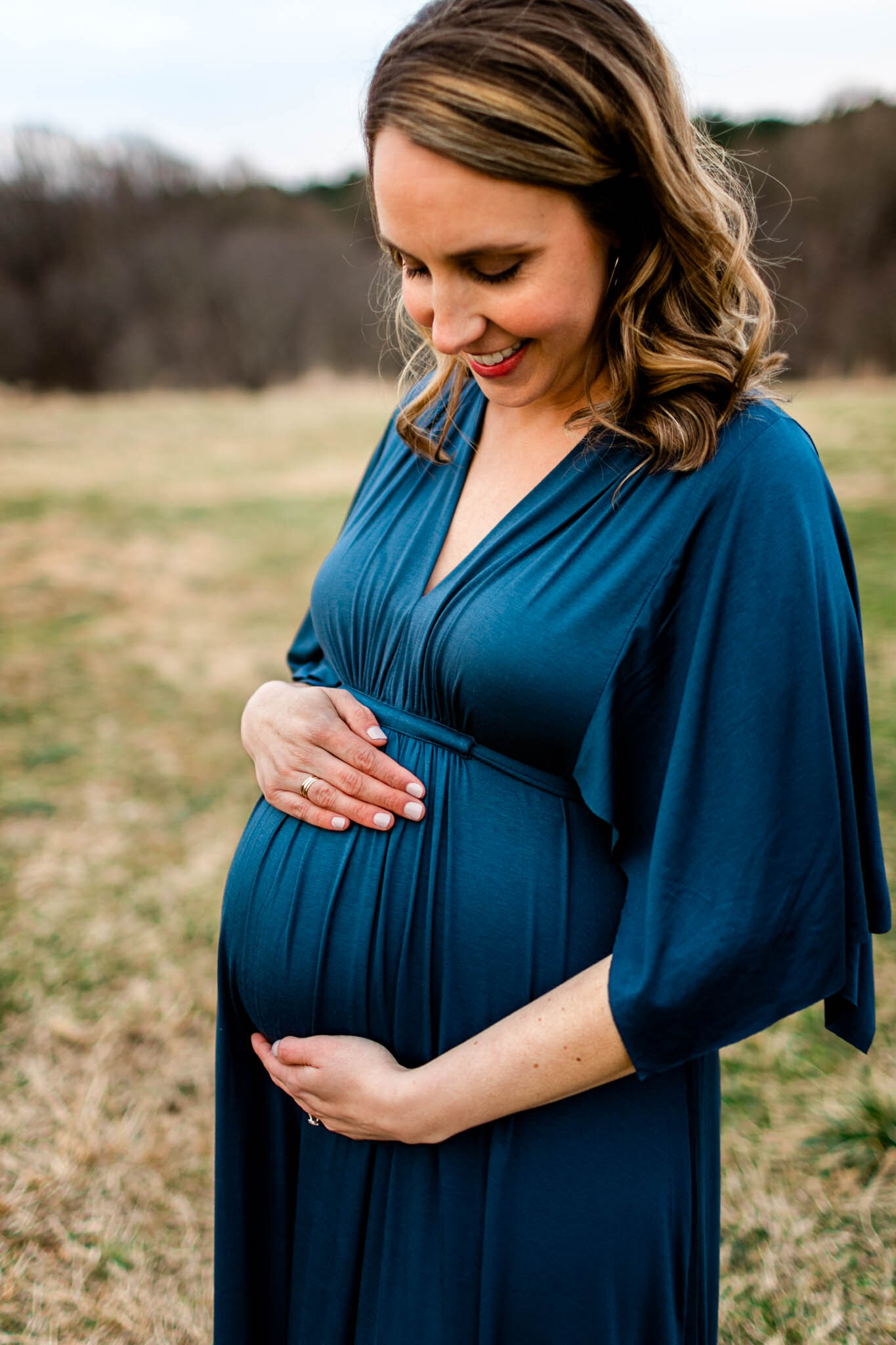 Raleigh Newborn Photographer | By G. Lin Photography | Woman smiling and looking down at baby bump