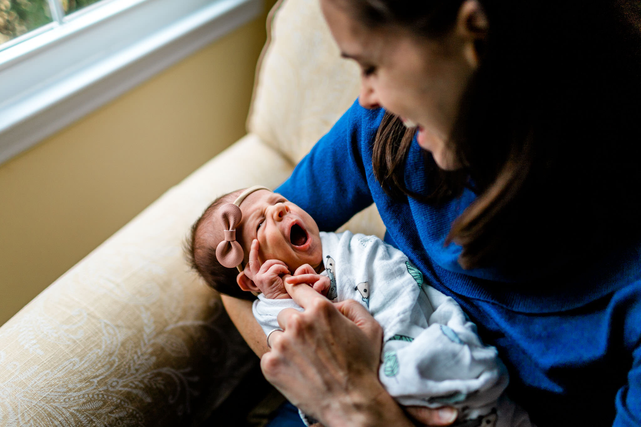 Durham Newborn Photographer | By G. Lin Photography | Mother wearing blue sweater holding baby next to window