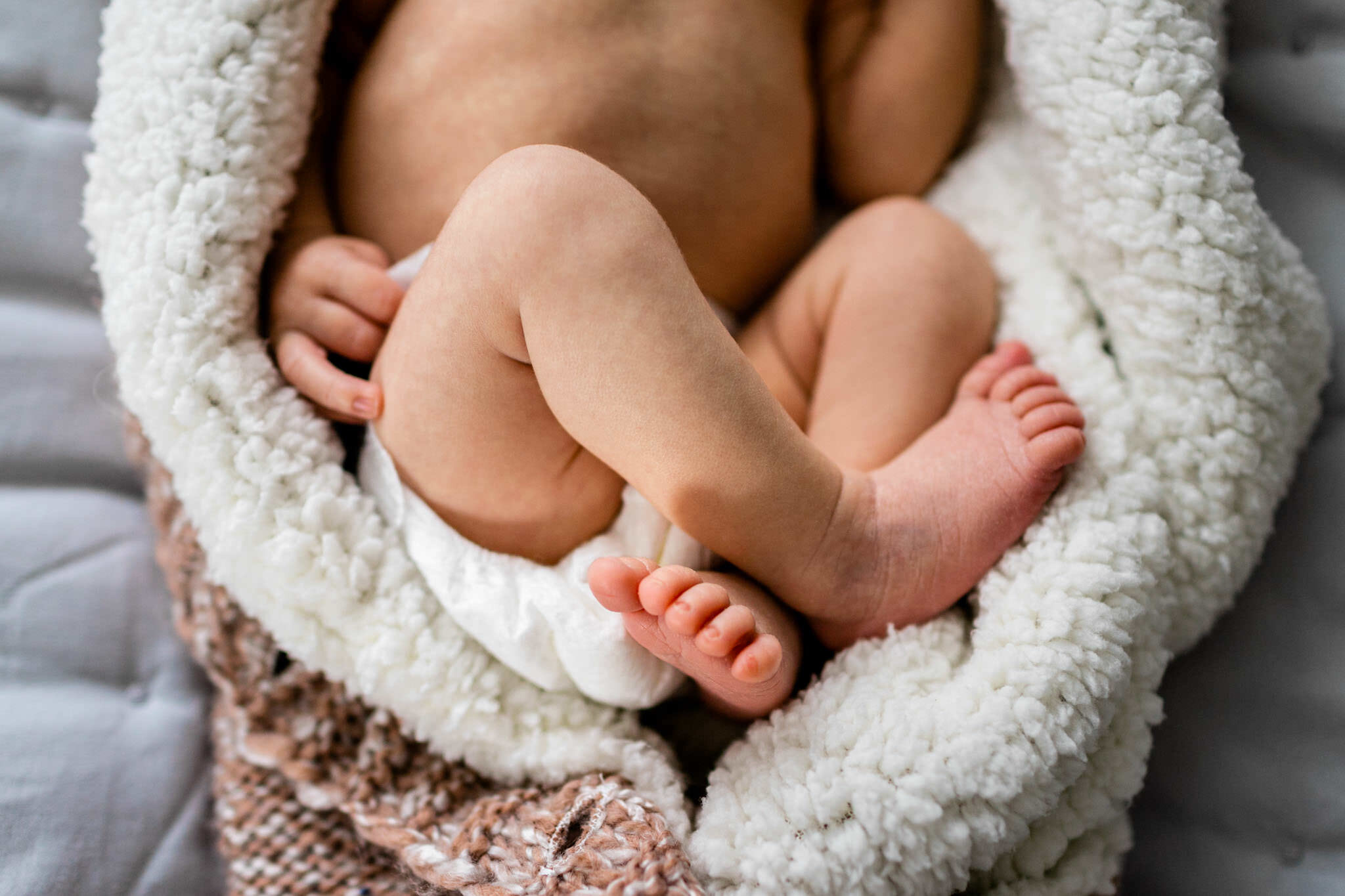 Durham Newborn Photographer | By G. Lin Photography | Baby's feets crossed together and laying in fleece swaddle