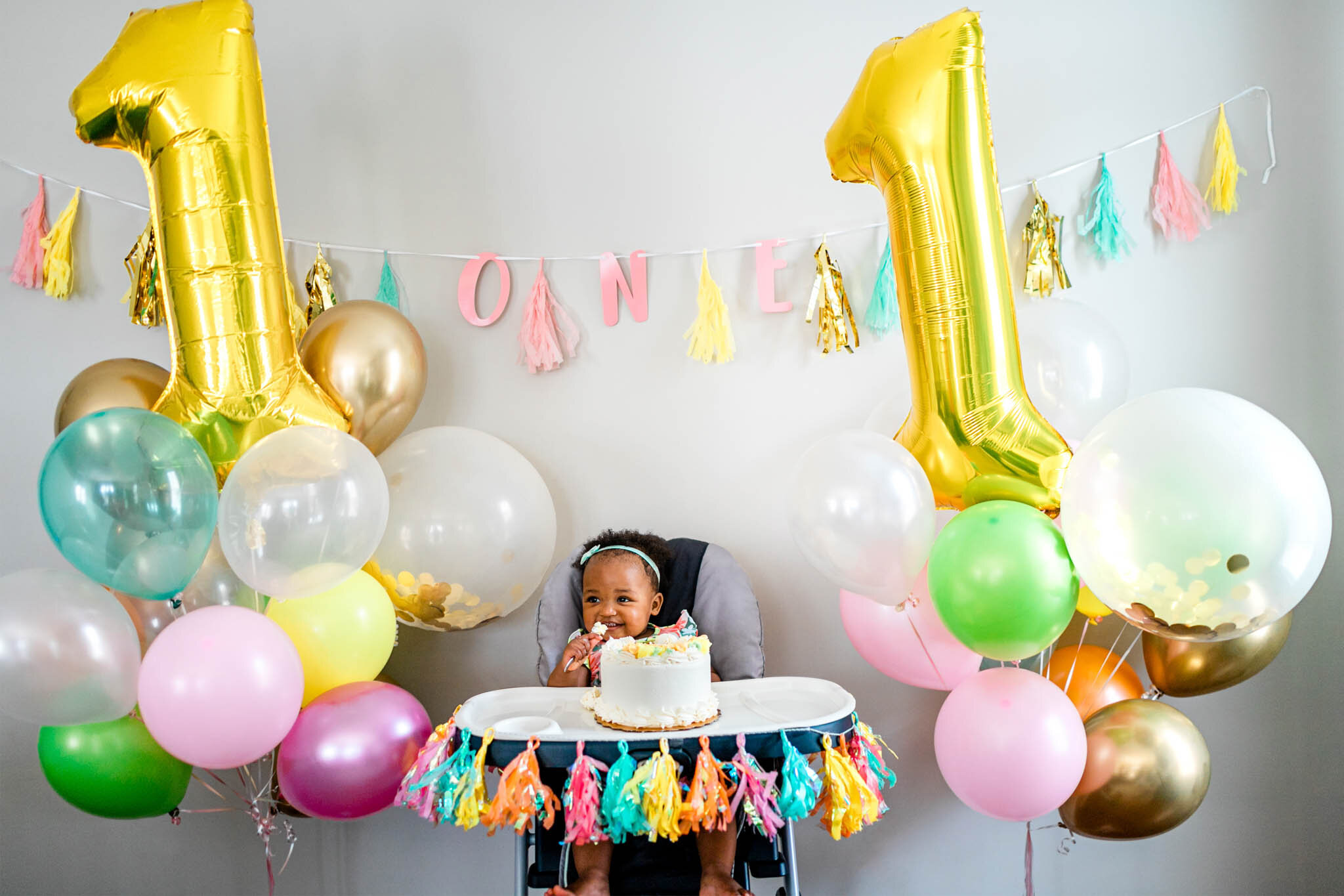 Durham Family Photographer | By G. Lin Photography | First birthday celebration | Baby girl turning one with balloons in the back