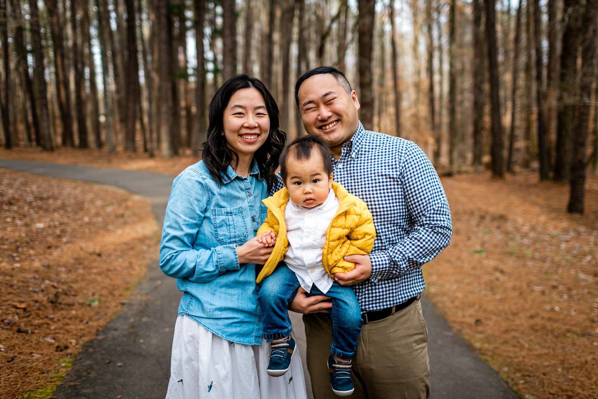 Raleigh Family Photographer | By G. Lin Photography | Umstead Park | Family of three standing in woods