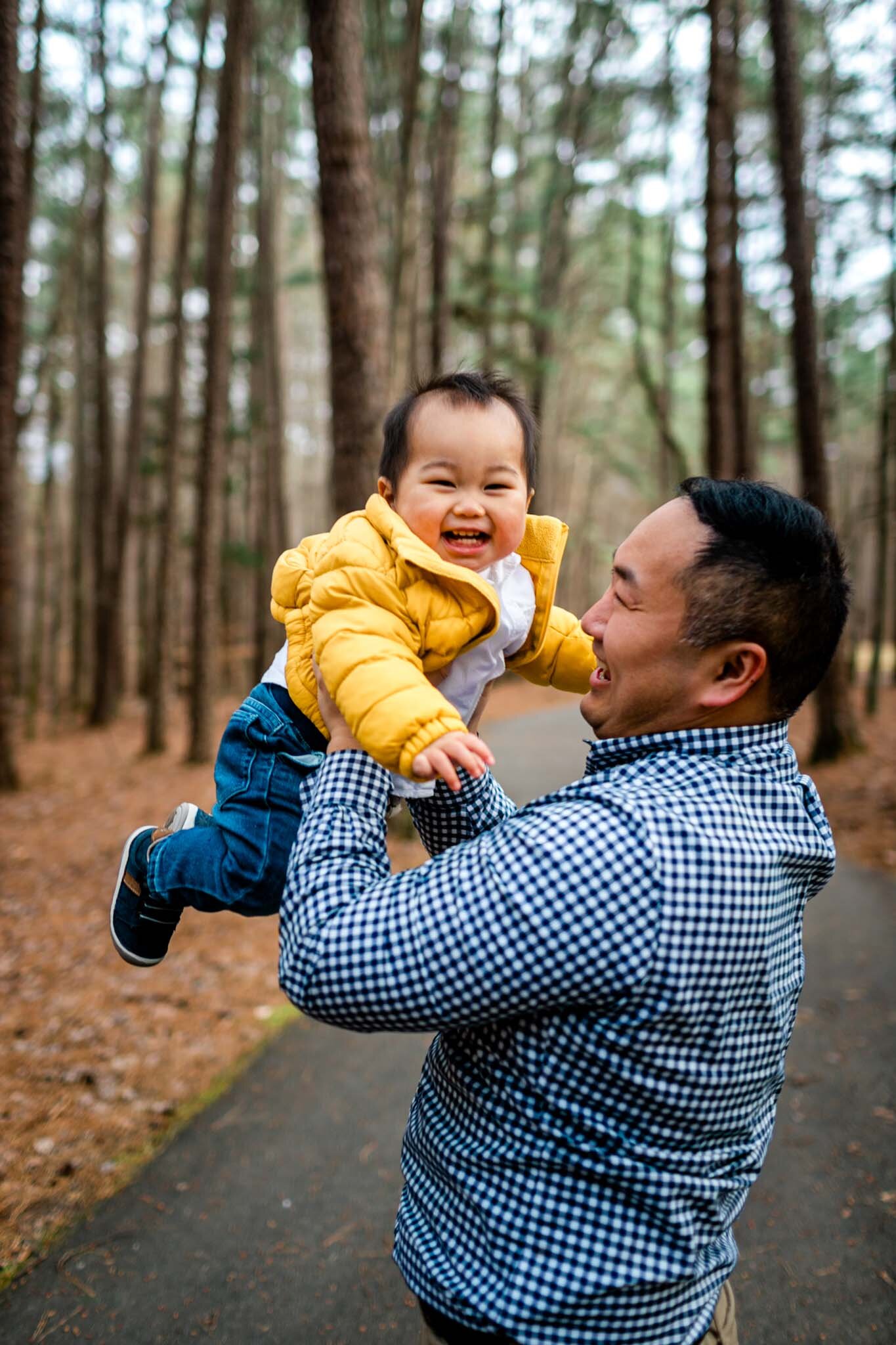 Raleigh Family Photographer | By G. Lin Photography | Umstead Park | Father tossing baby in the air and laughing
