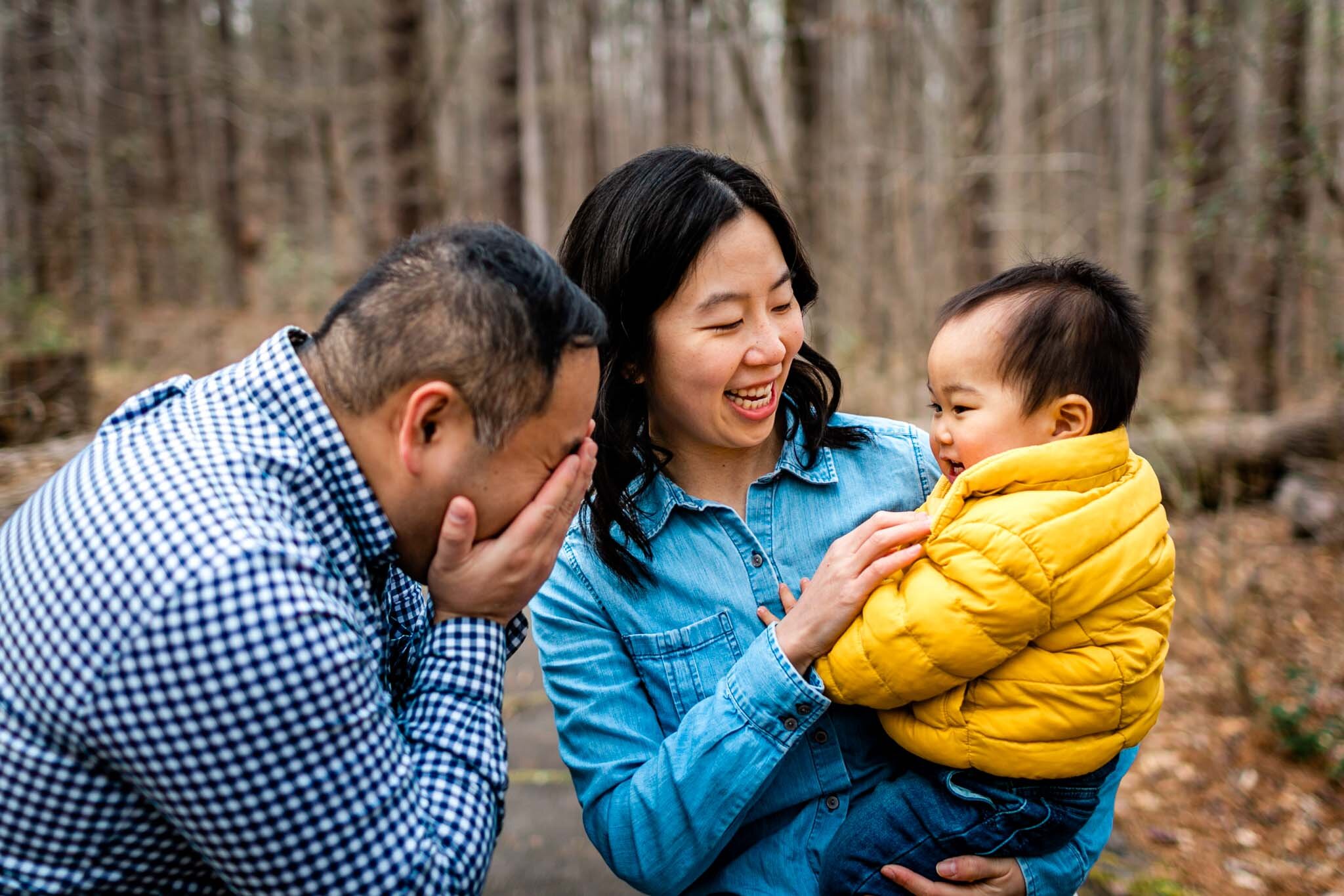 Raleigh Family Photographer | By G. Lin Photography | Umstead Park | Parents playing peek a boo with baby