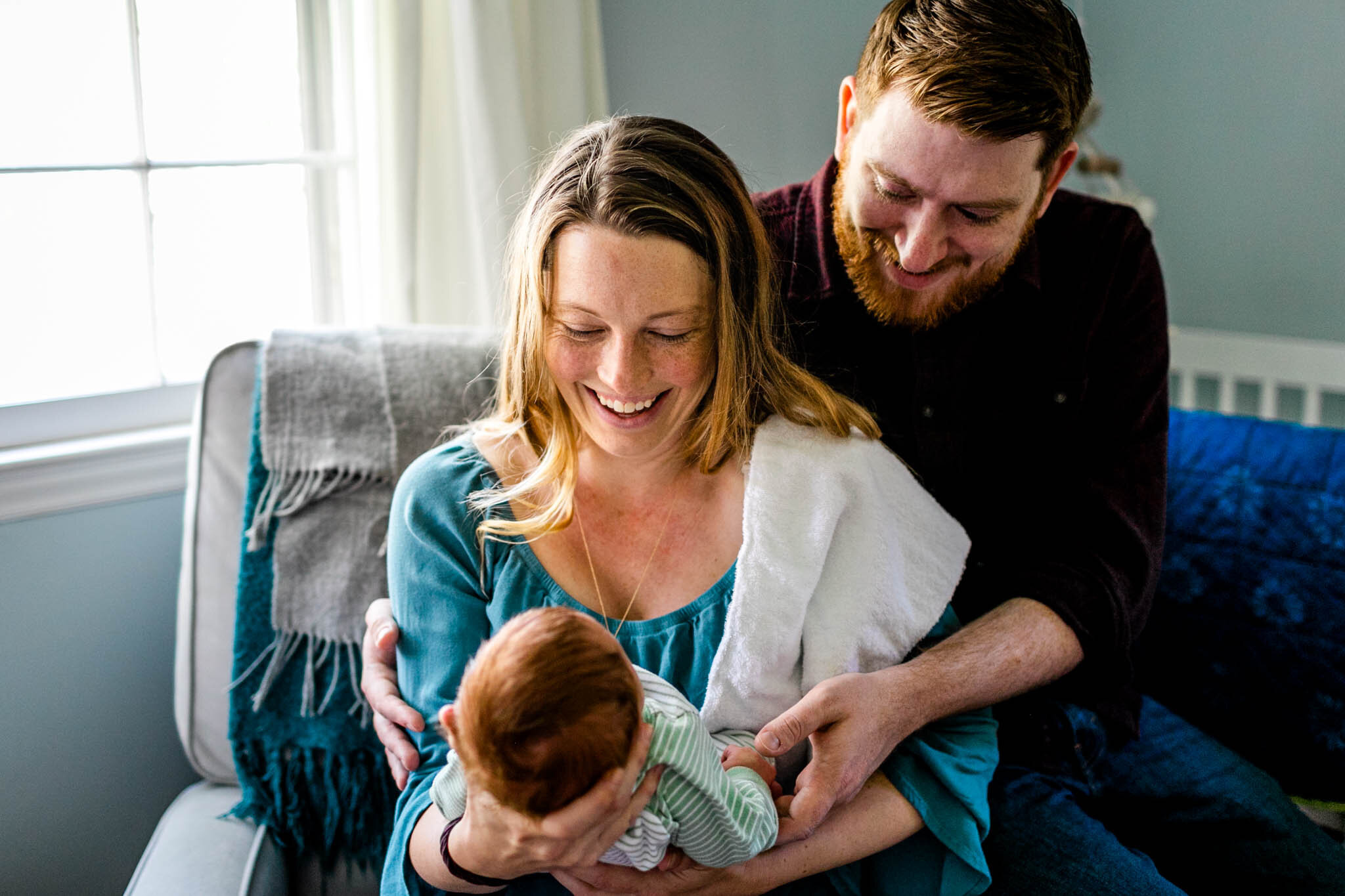 Durham Newborn Photographer | By G. Lin Photography | Mother and father holding baby girl by window