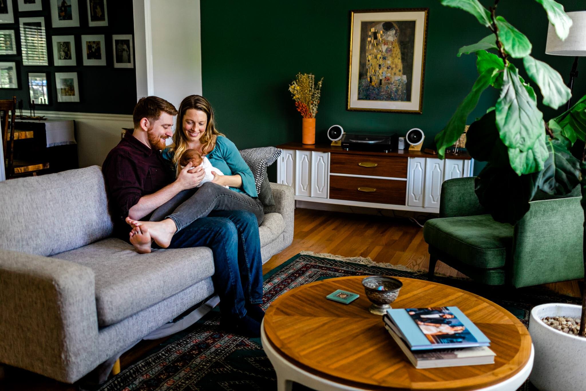 Durham Newborn Photographer | By G. Lin Photography | Man and woman sitting on couch with baby girl