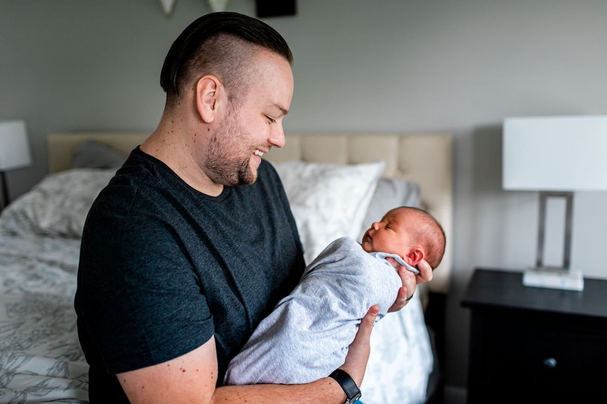 Father holding baby inside home | Holly Spring Newborn Photographer | By G. Lin Photography | Lifestyle newborn photography
