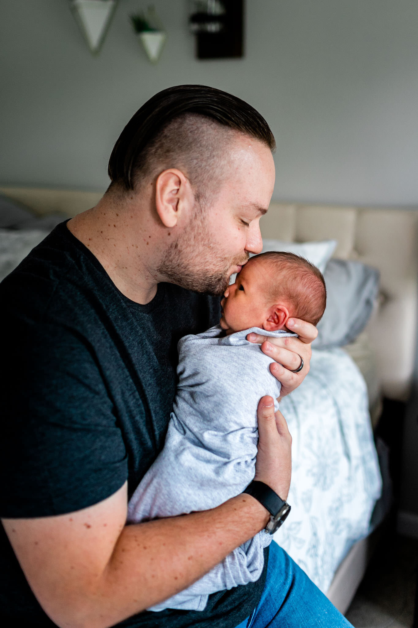 Father kissing baby on forehead | Holly Spring Newborn Photographer | By G. Lin Photography | At home lifestyle newborn photography