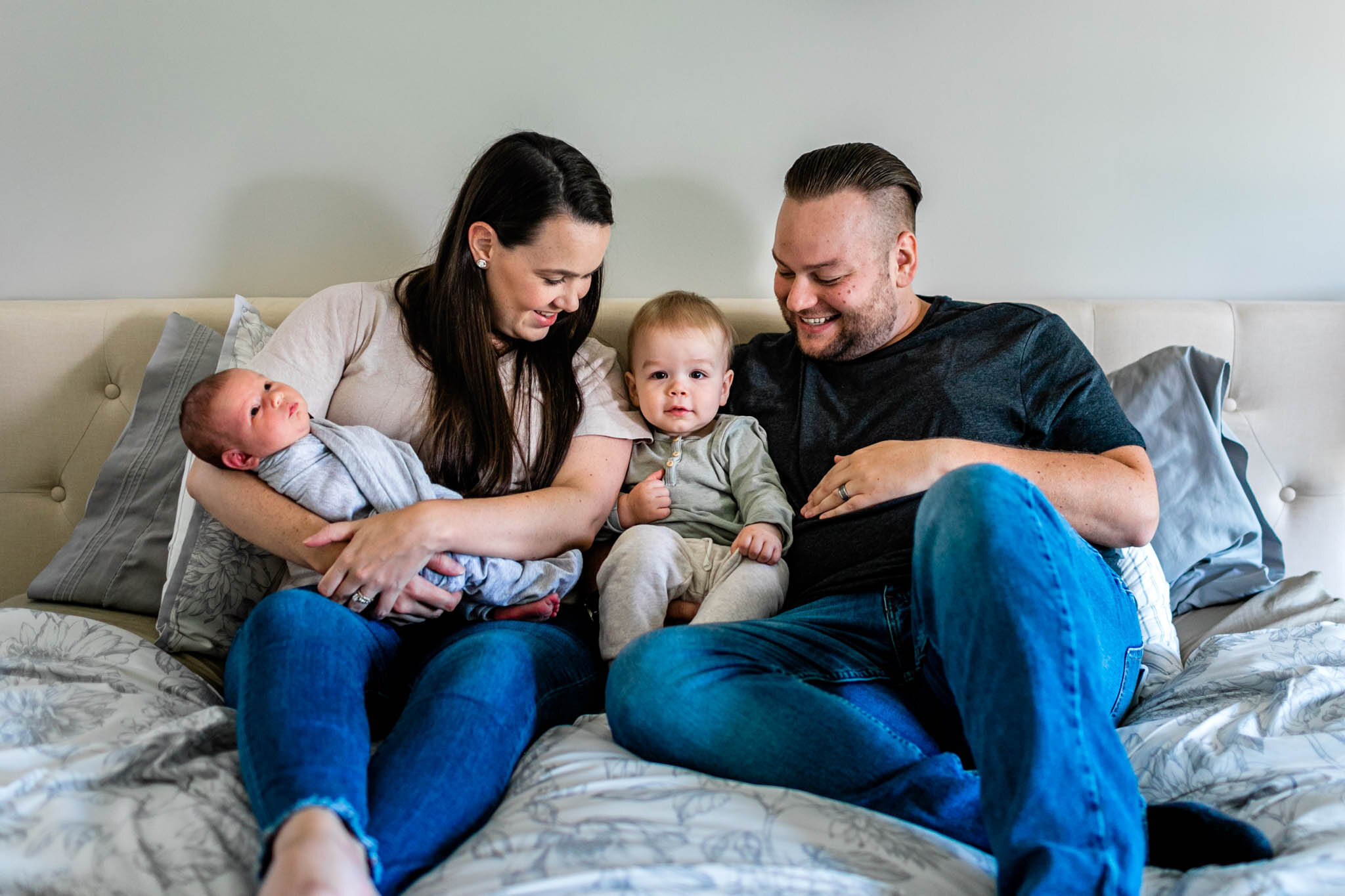 Family sitting on bed together | Lifestyle newborn photography at home | Holly Spring Newborn Photographer | By G. Lin Photography