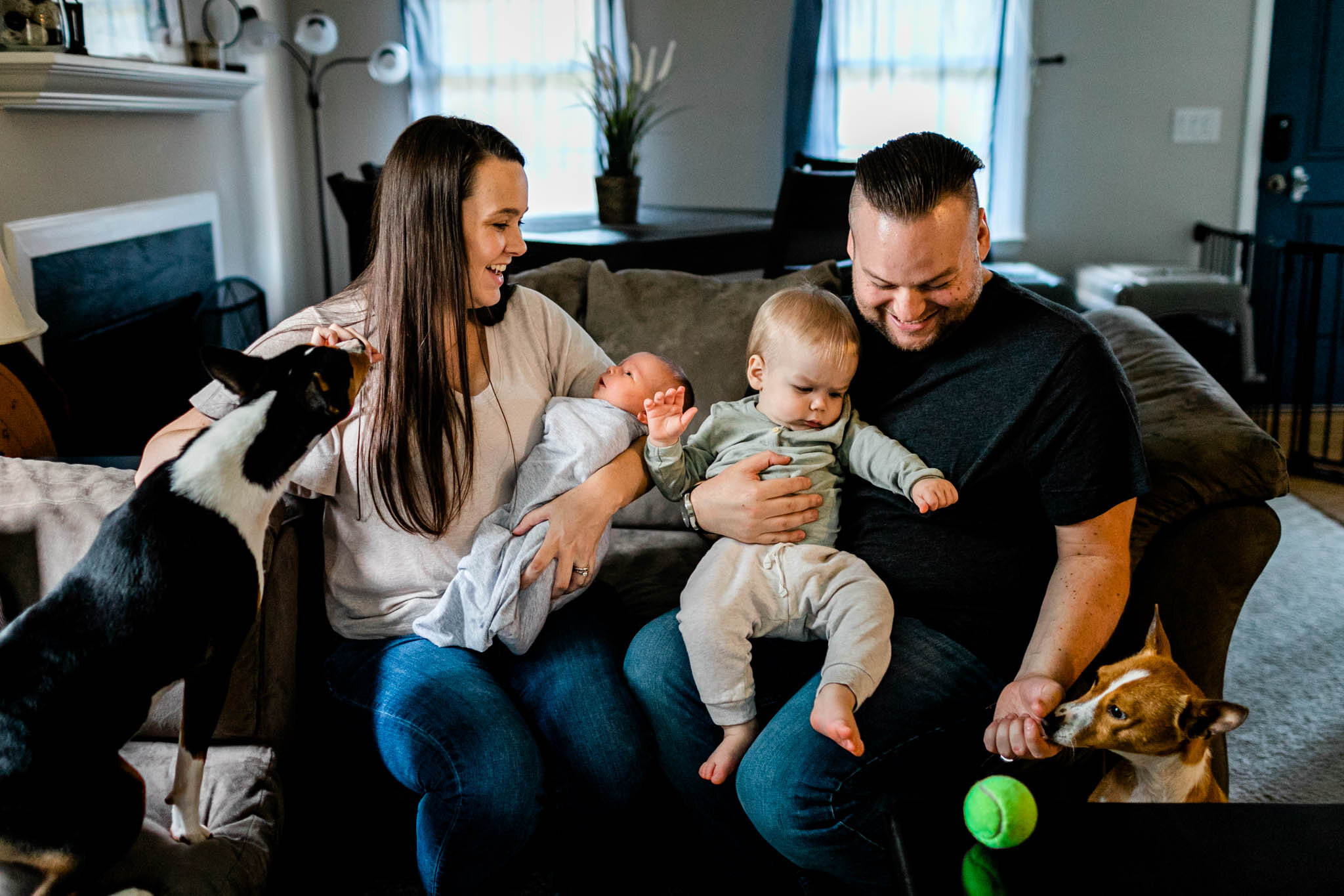 Family laughing and playing with dogs on couch | Holly Spring Newborn Photographer | By G. Lin Photography