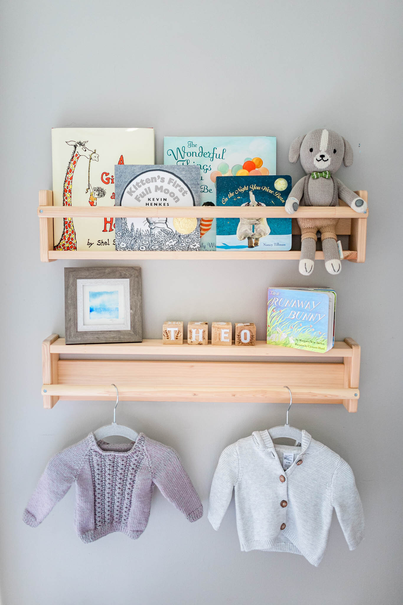 Books and baby clothing hung on the wall | Lifestyle newborn photography at home | Greensboro Newborn Photographer | By G. Lin Photography