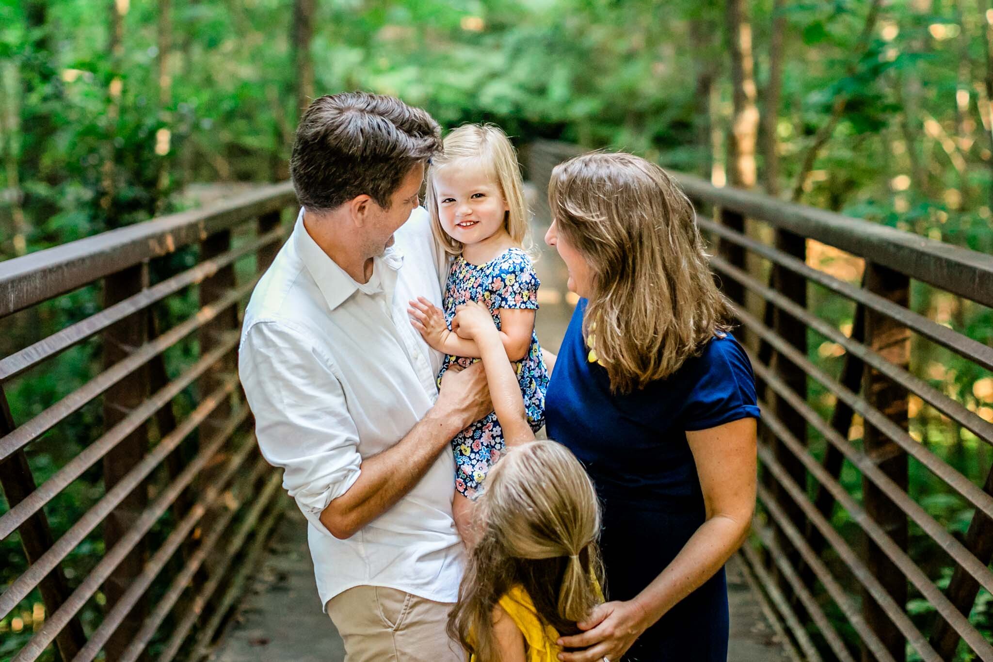 Candid family of four laughing outside at North Cary Park | Cary Family Photographer | By G. Lin Photography 