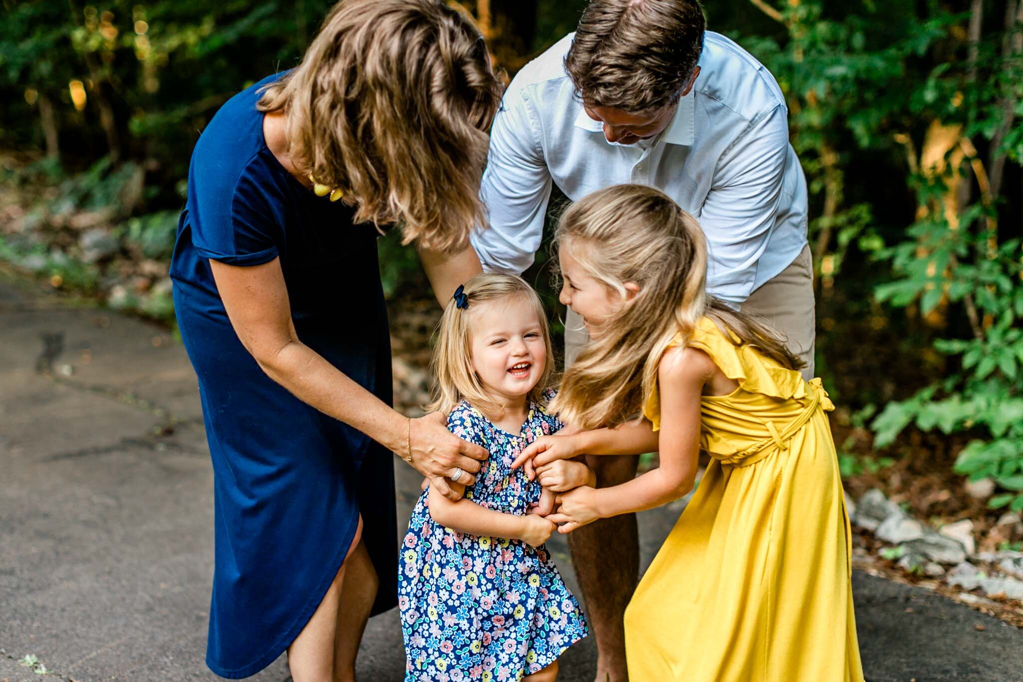 Family tickling young girl and laughing together | Cary Family Photographer | By G. Lin Photography