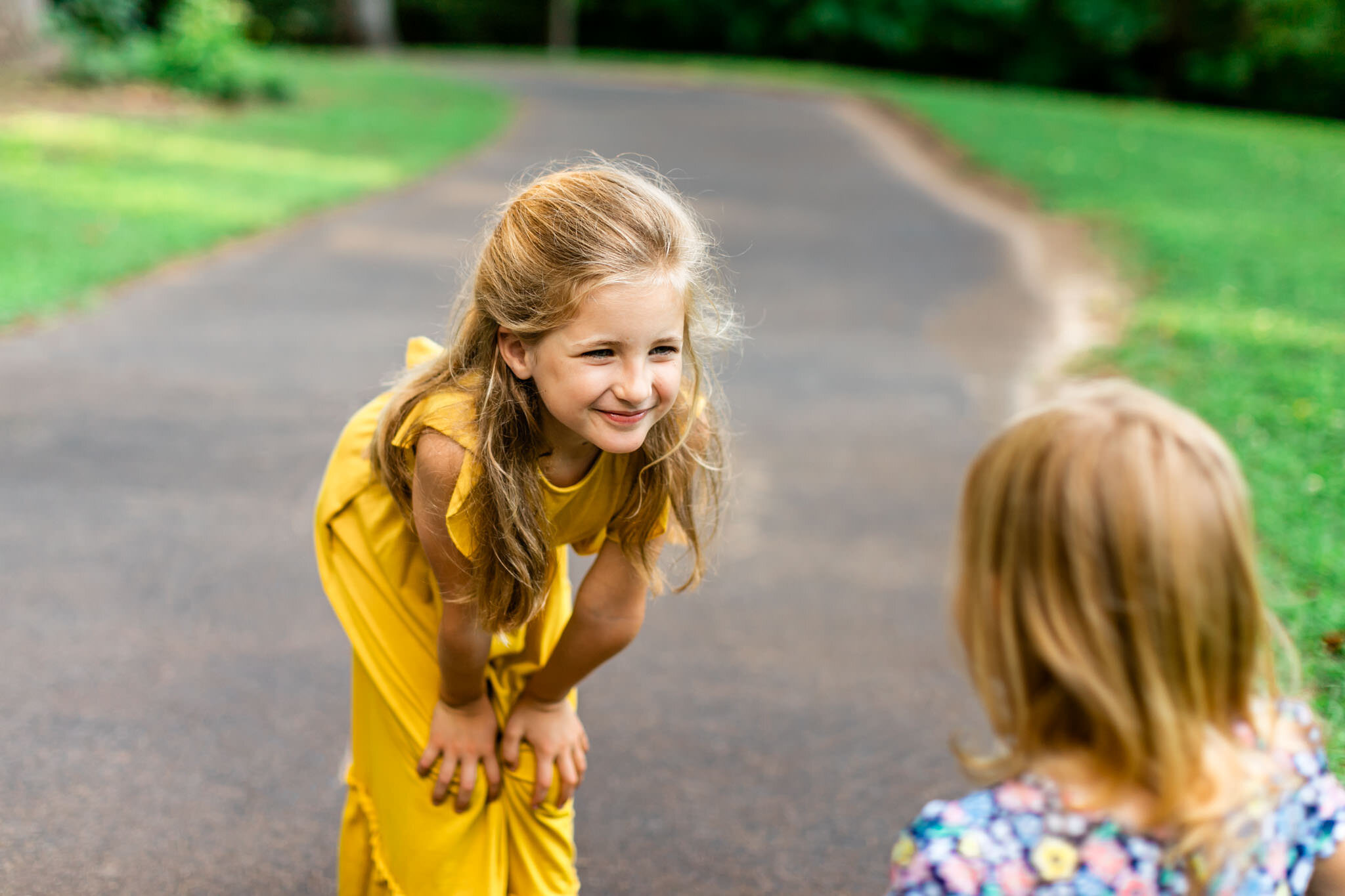 Sisters smiling at each other | North Cary Park | Cary Family Photographer | By G. Lin Photography