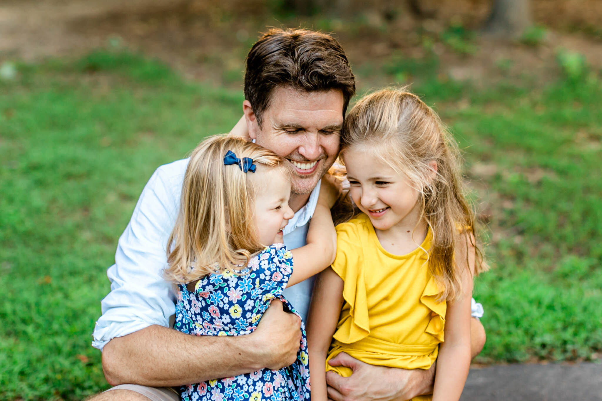 Father hugging two young daughters | Cary Family Photographer | By G. Lin Photography