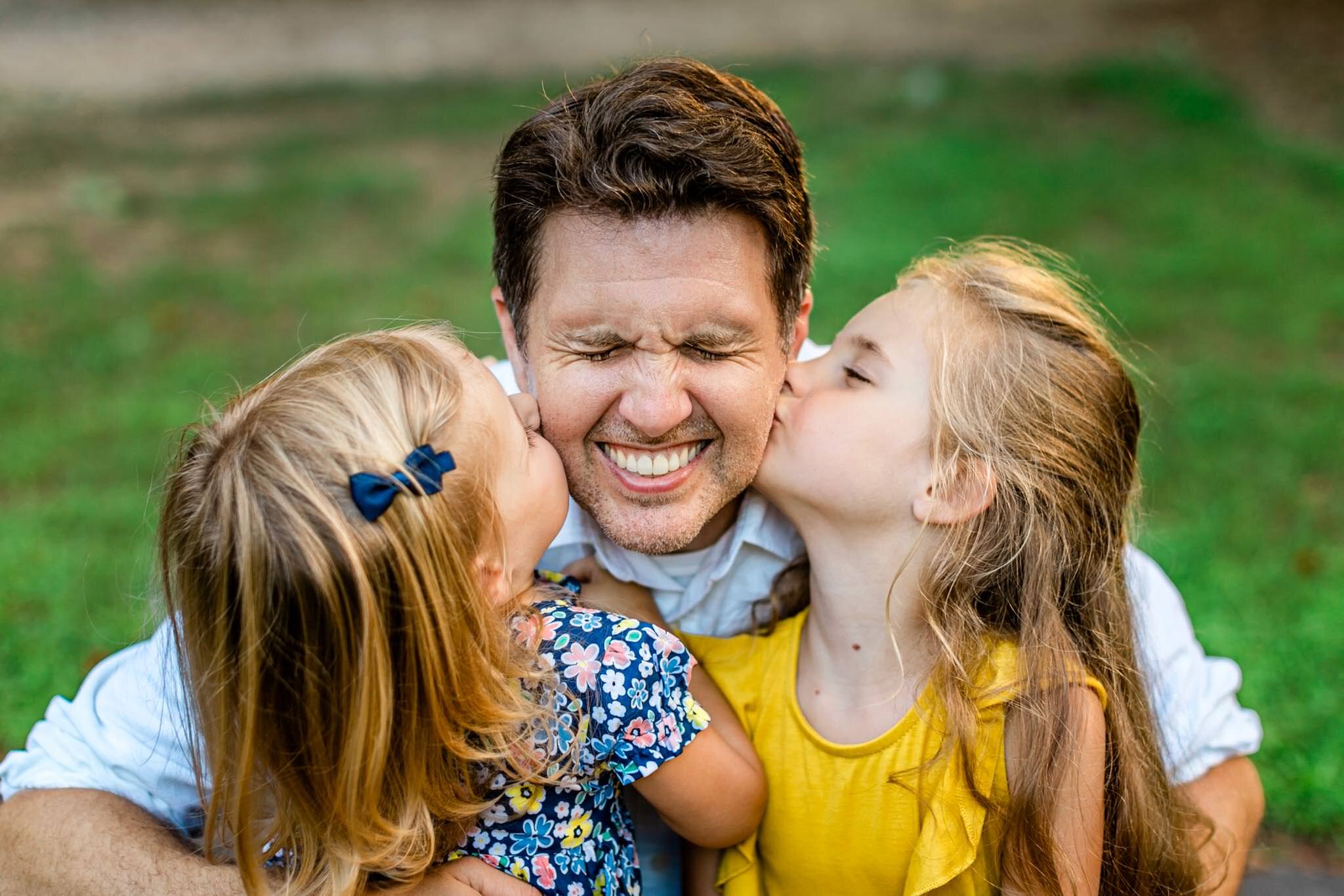 Young daughters kissing father on the cheek | North Cary Park | Cary Family Photographer | By G. Lin Photography