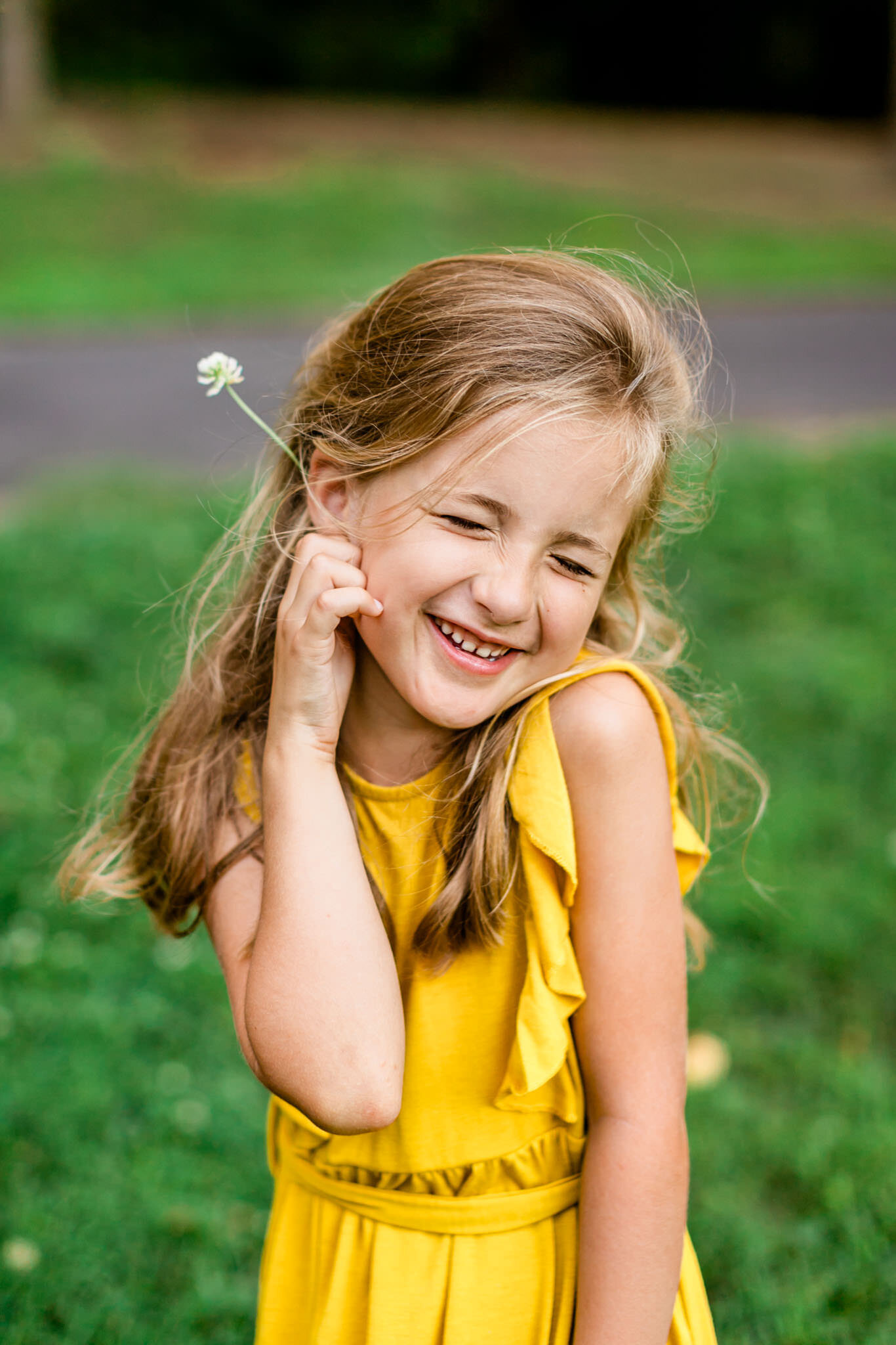 Girl in yellow dress smiling and holding flower | Cary Family Photographer | By G. Lin Photography