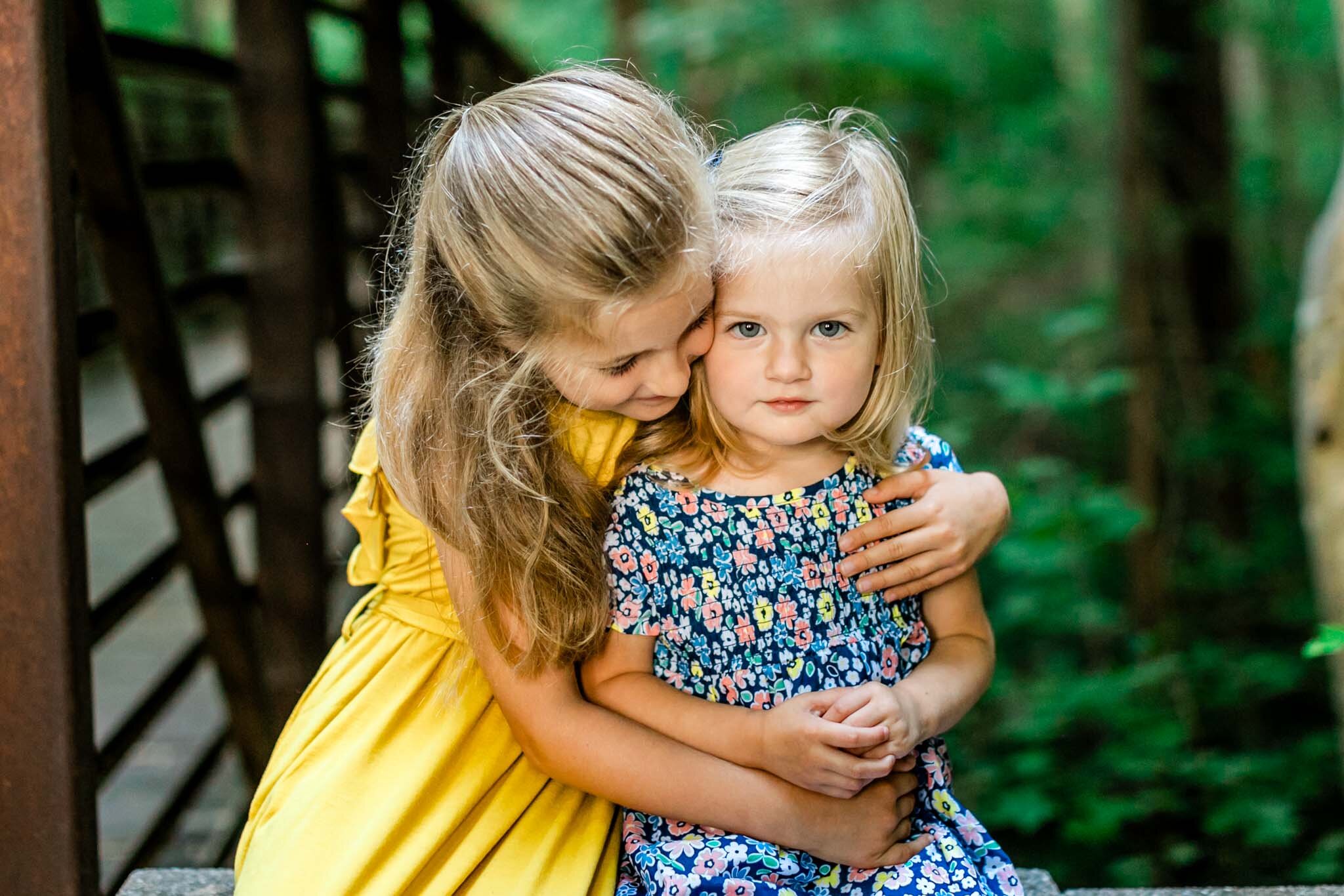 Girl in yellow dress hugging younger sister | Cary Family Photographer | By G. Lin Photography