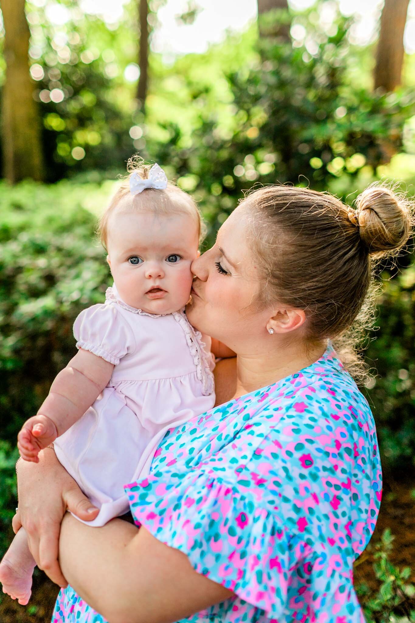 Mother kissing baby girl wearing pink | Raleigh Family Photographer | By G. Lin Photography | WRAL Azalea Garden