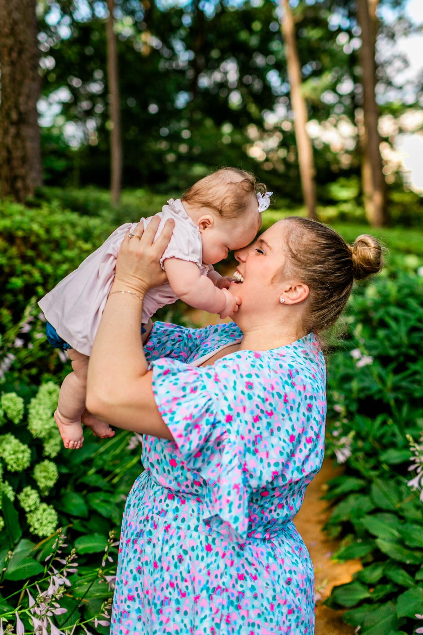 Candid moment of mother kissing baby | Raleigh Family Photographer | By G. Lin Photography | WRAL Azalea Garden