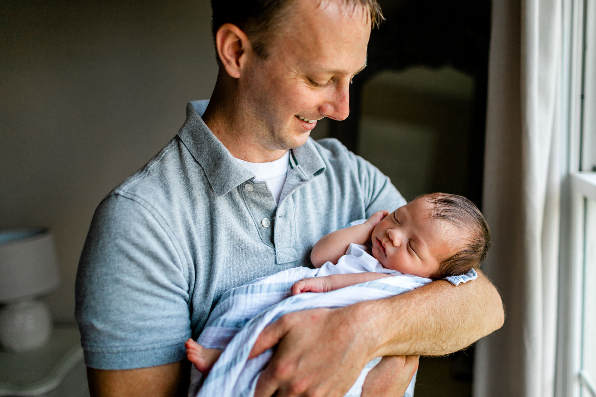 Father looking and holding baby boy | Durham Newborn Photographer | By G. Lin Photography